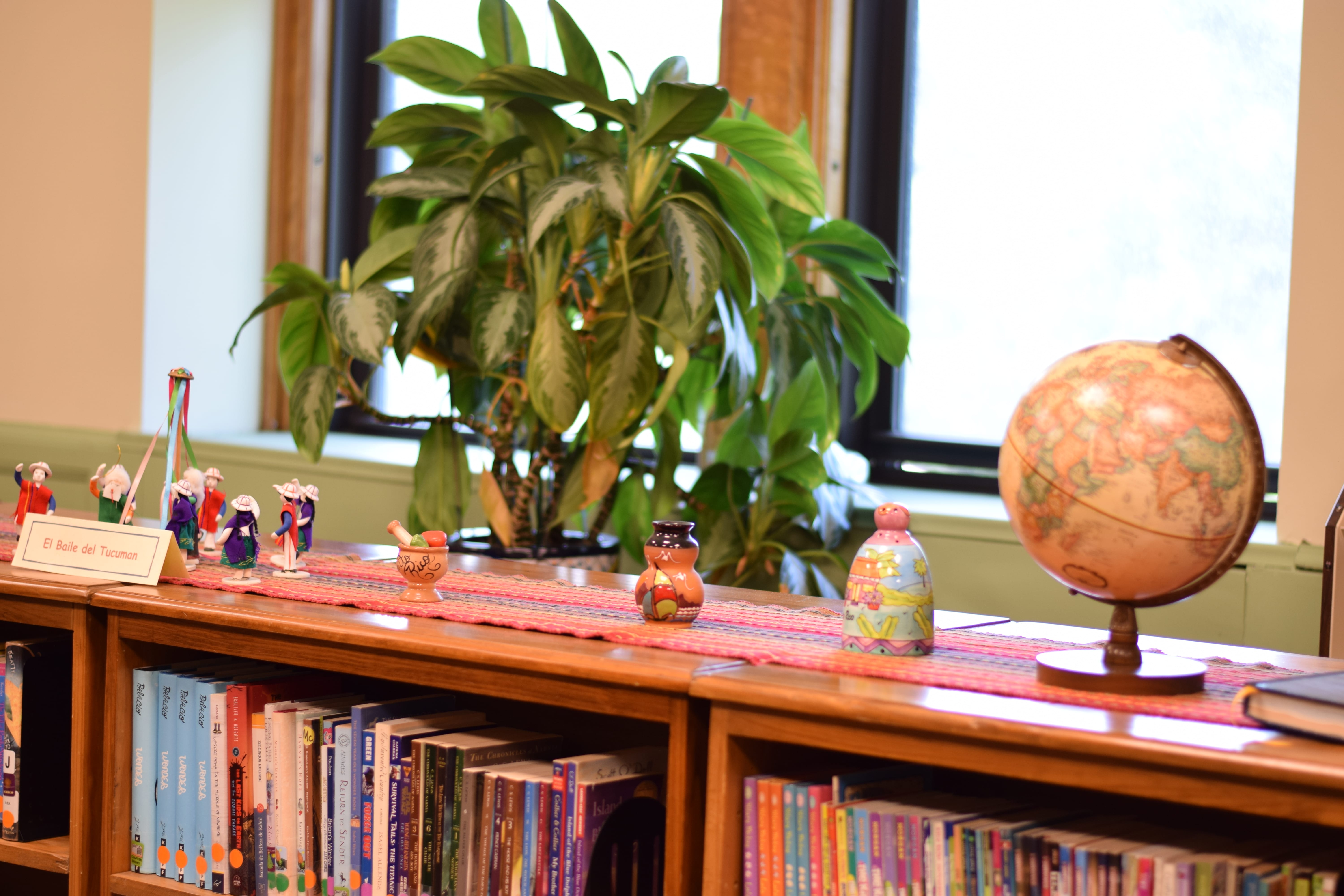 Small decorations - a globe and other figures are standing on the bookshelf. 