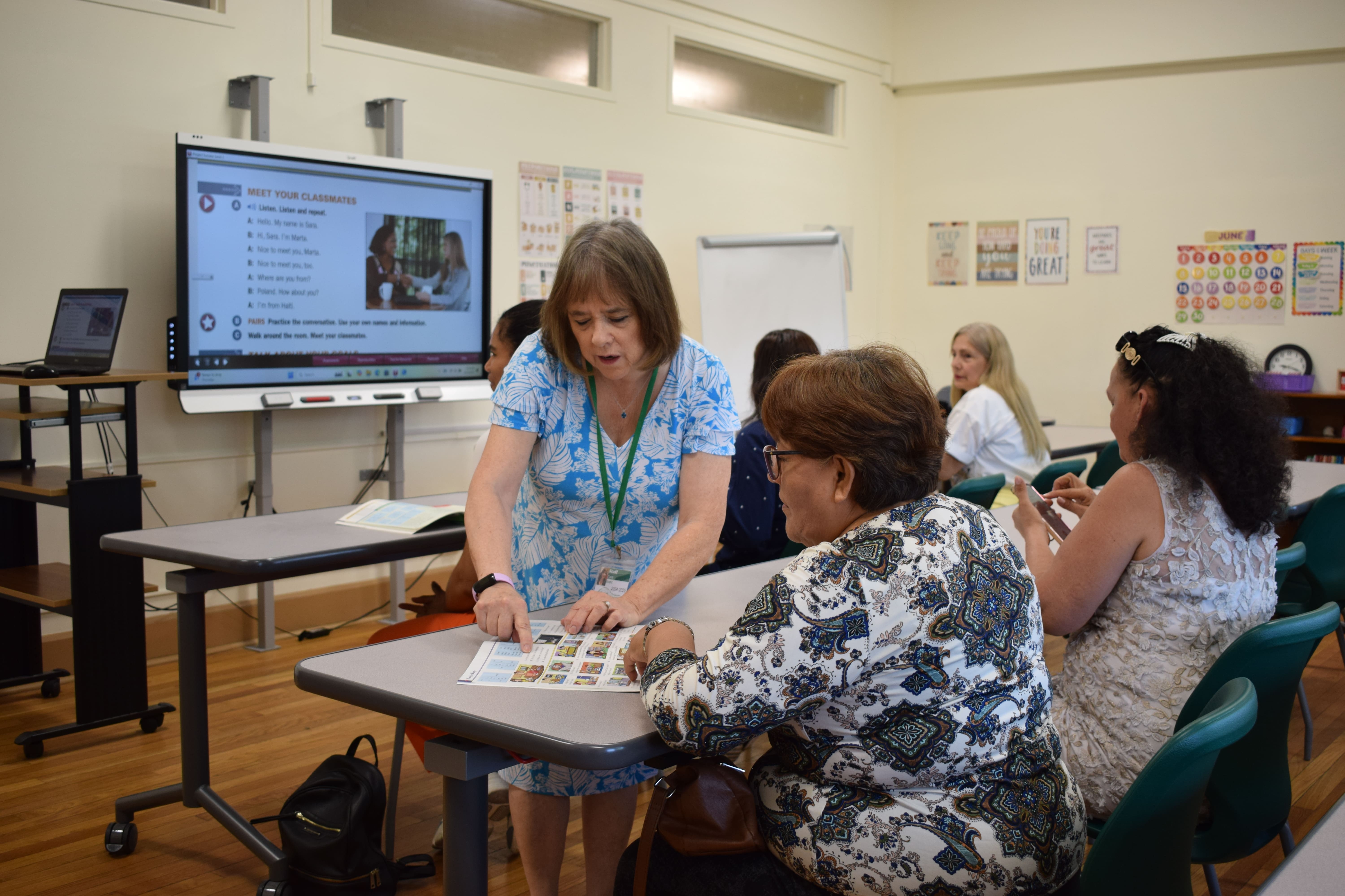 The teacher is reading the material from the paper with the student. 