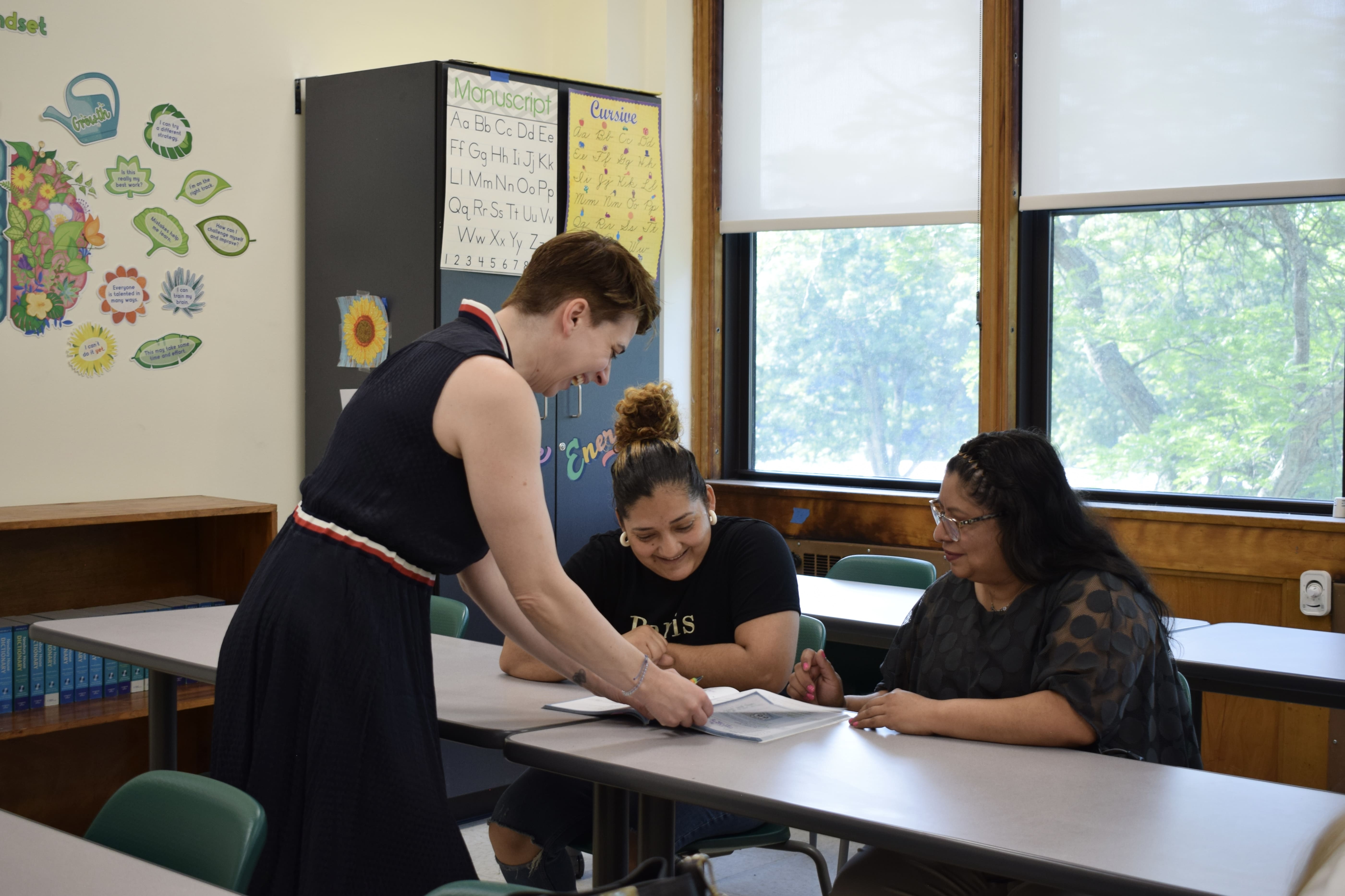 The teacher is explaining the material to two students privately. 