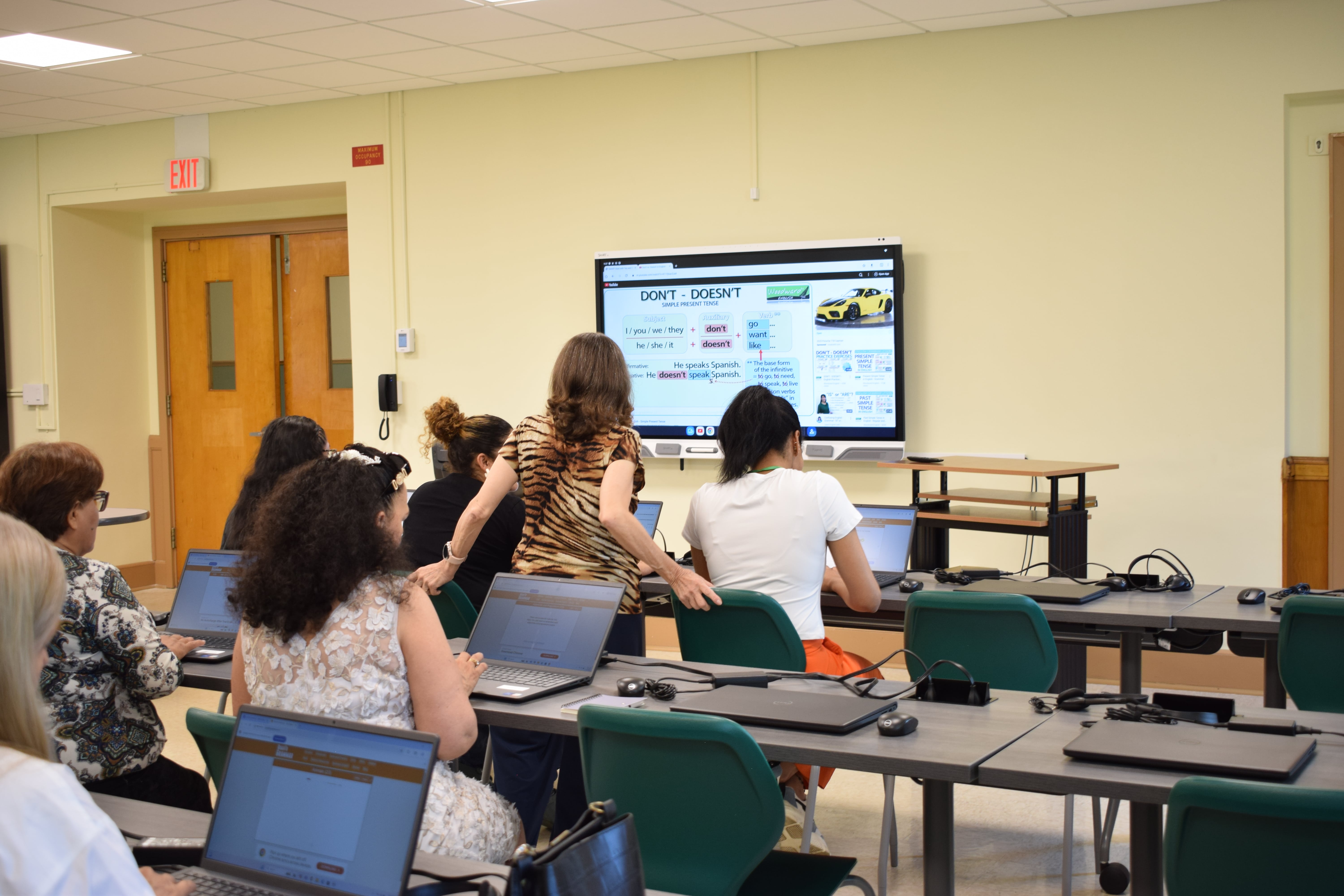 Students in a classroom seen from behind, looking at the blackboard.