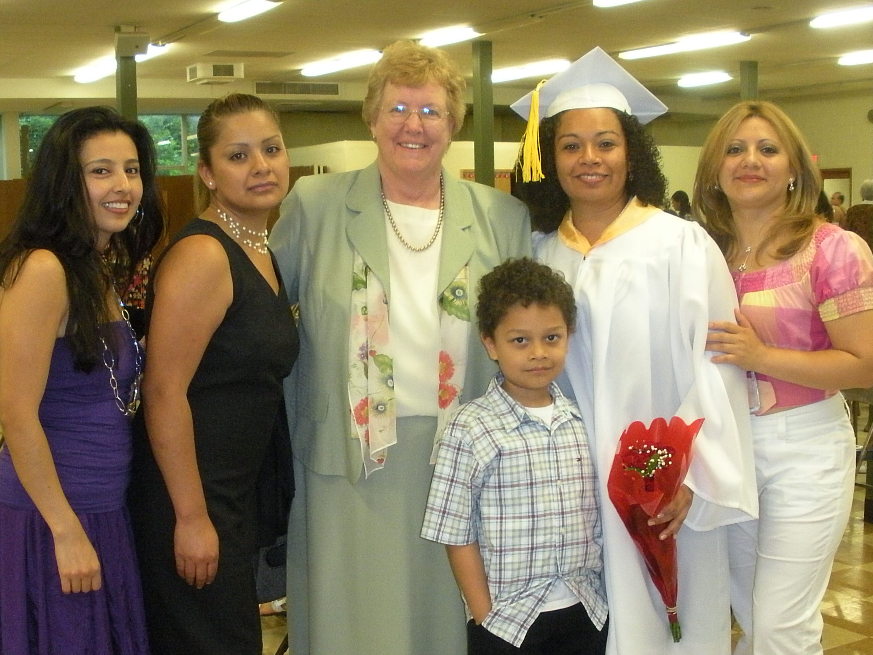 Sister Kathleen Carberry with a student receiving an award, surrounded by the student’s family.
