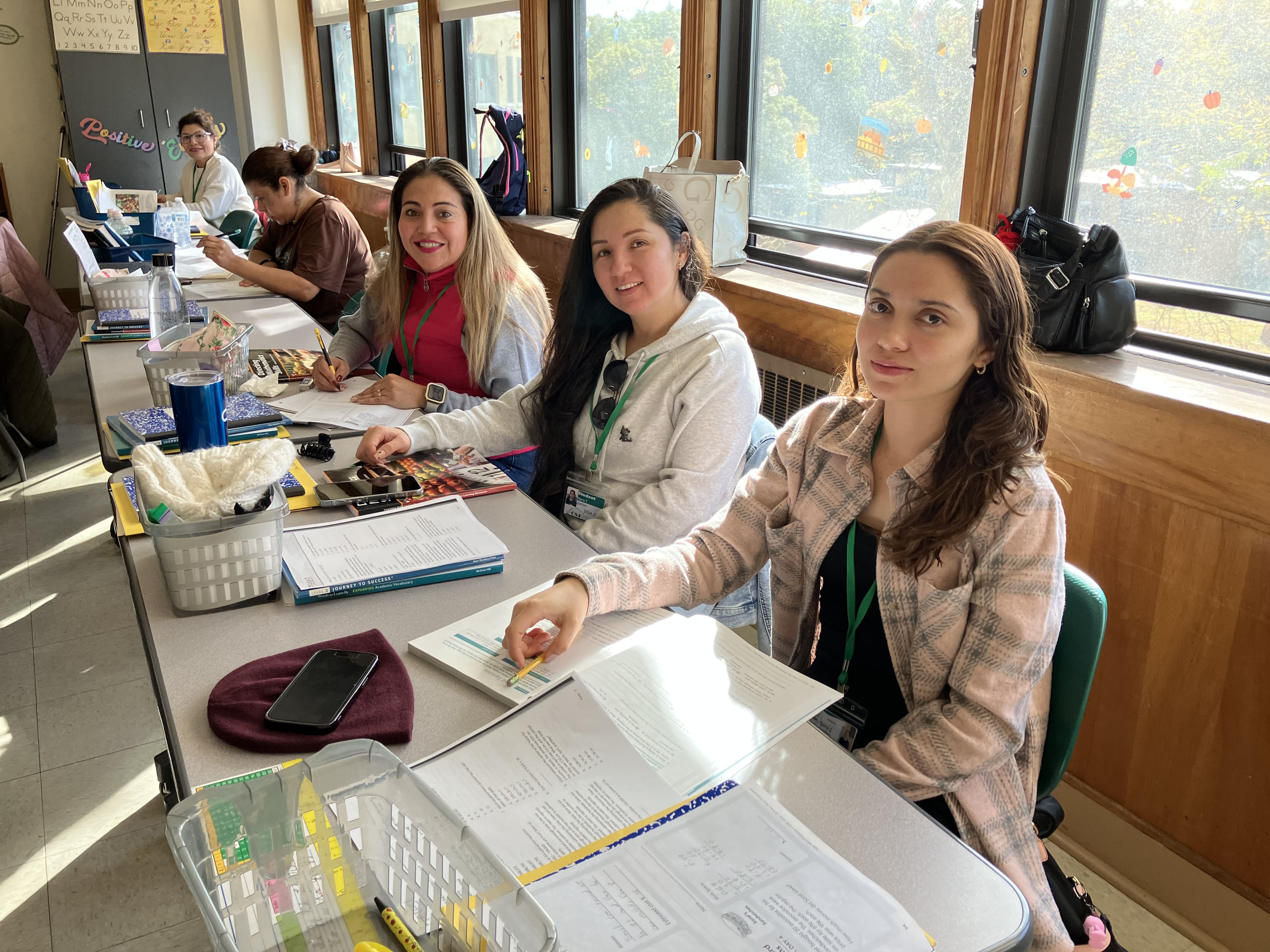 Women studying in a classroom, looking at the camera.