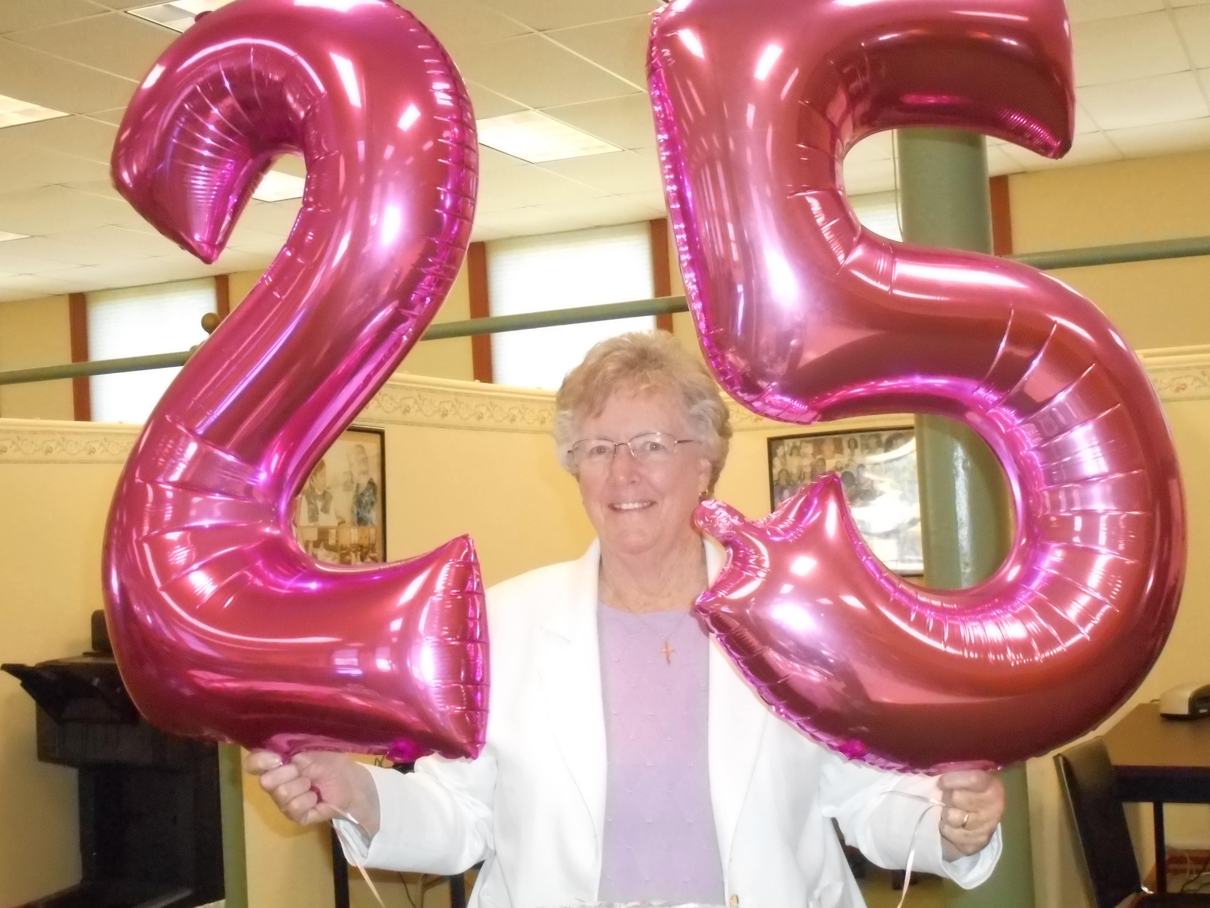 Sister Kathleen Carberry holding balloons during TLC’s 25th anniversary celebration.