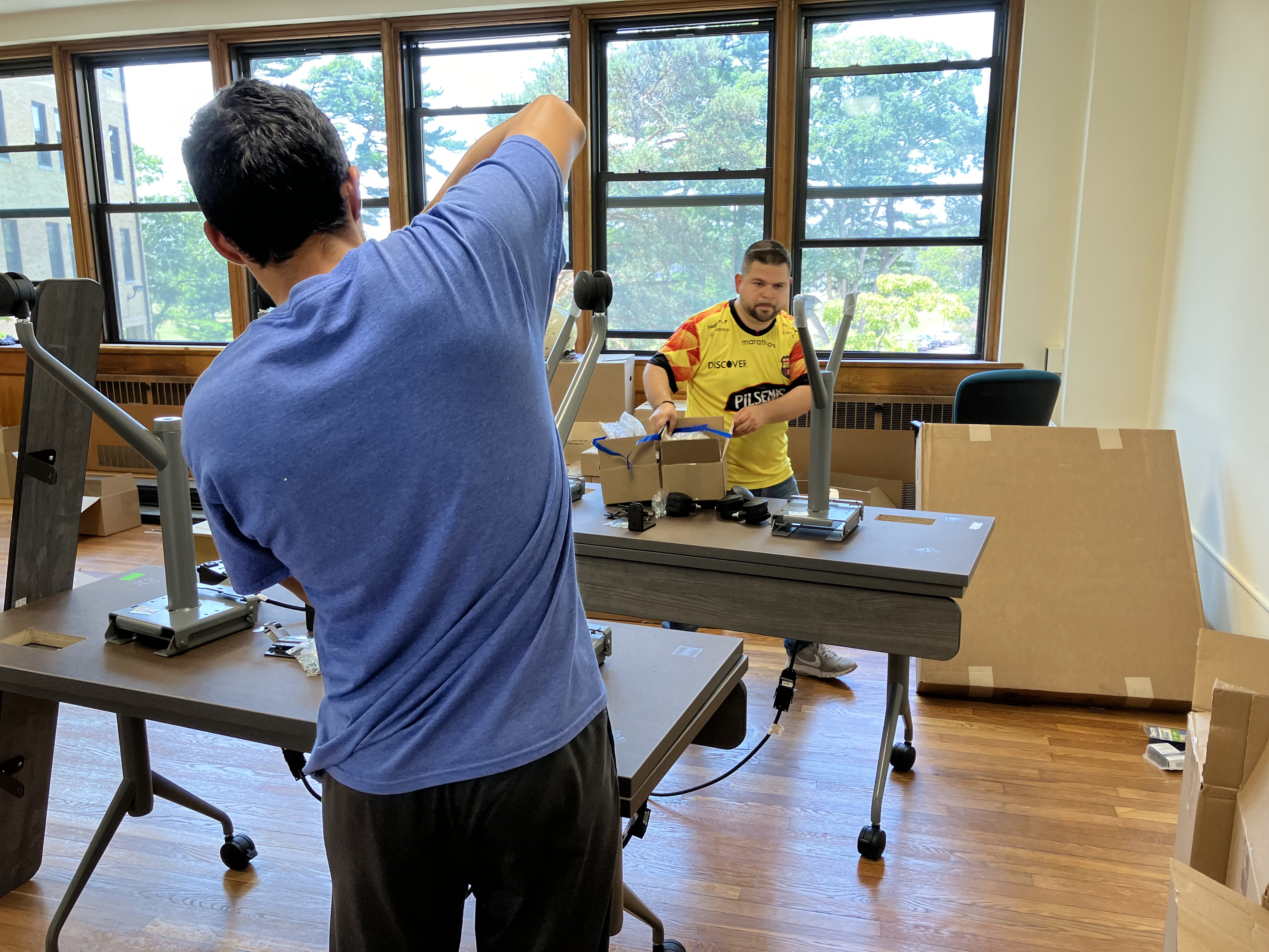 Two men are working hard to put new equipment in the new classrooms of TLC. 