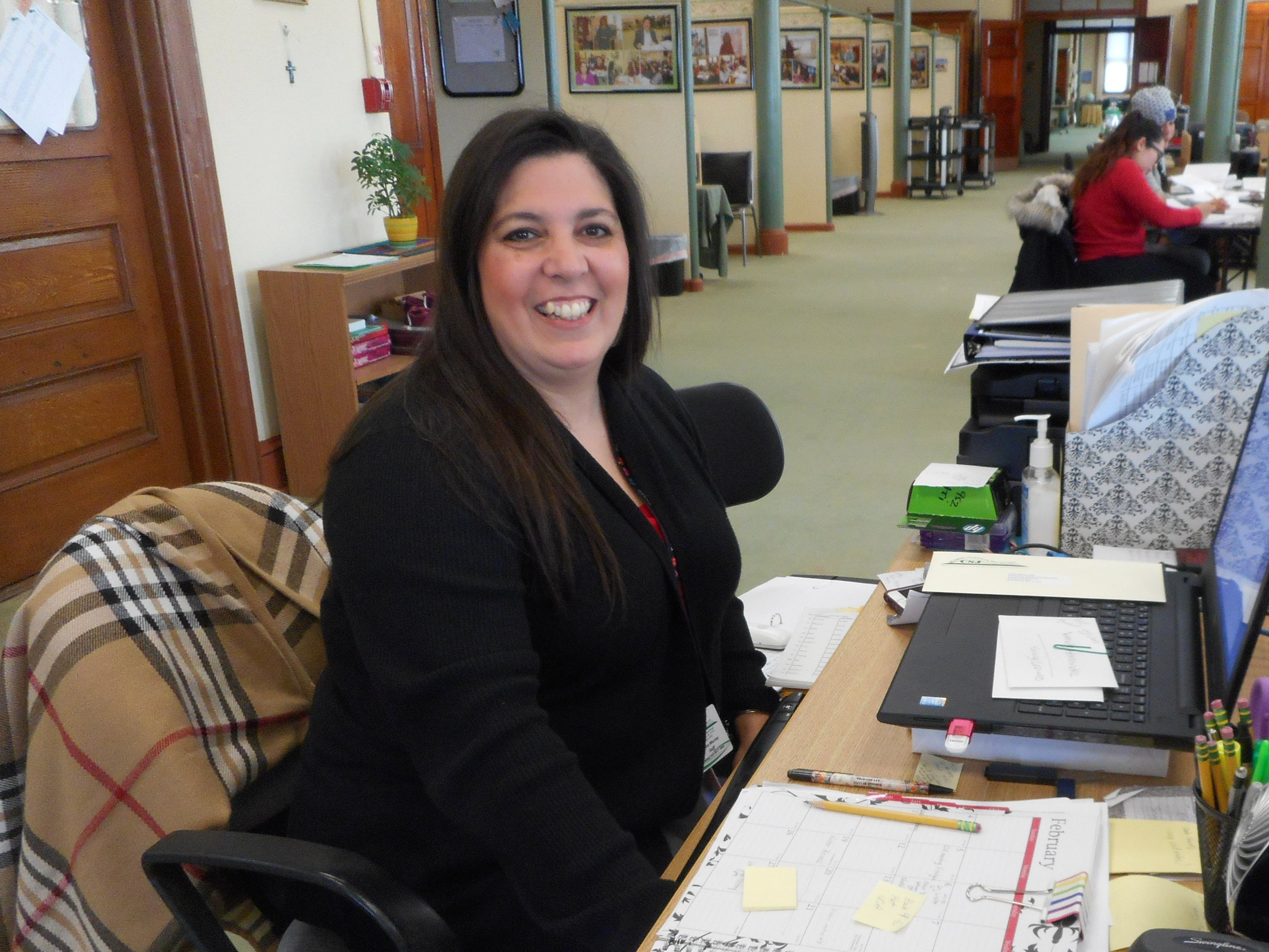Denise Murray is sitting at the desk. 