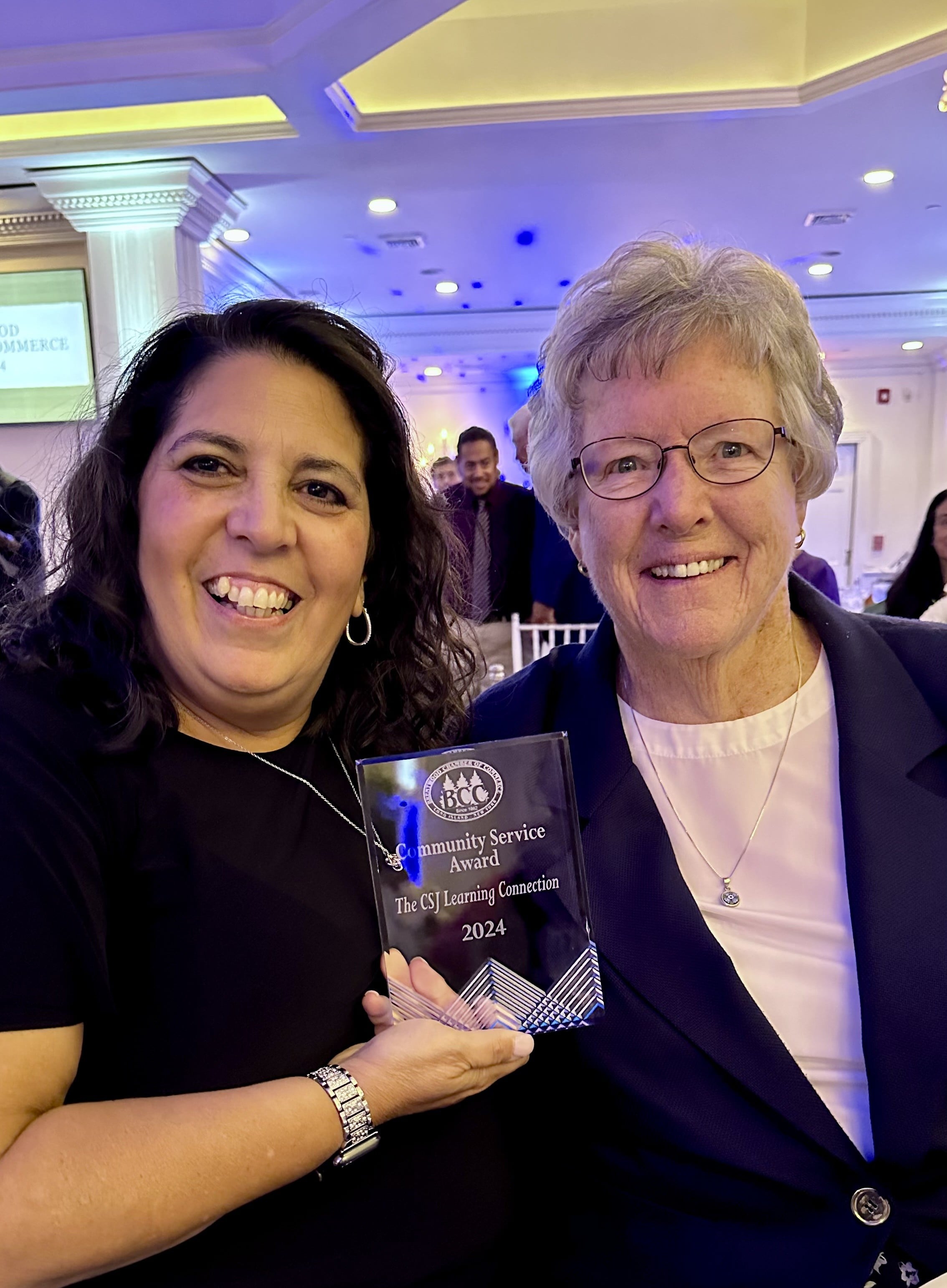 Denise Murray and Sister Kathleen are holding an award together.