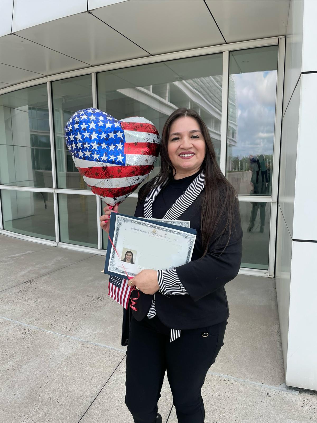 A TLC student holding his certificate of citizenship, with the balloon. 