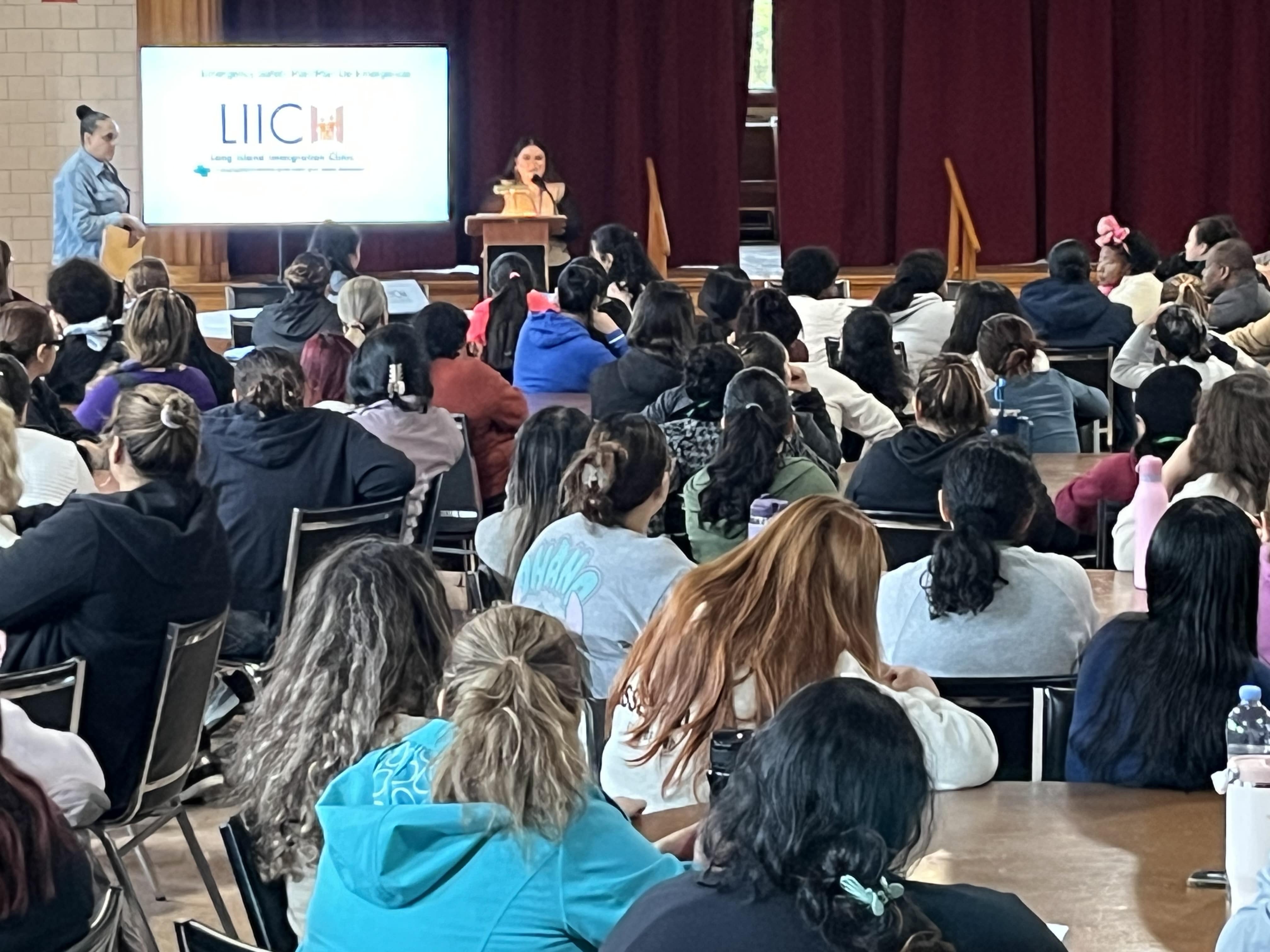 Audience listening during a Long Island Immigration Clinic event supporting immigrant communities.