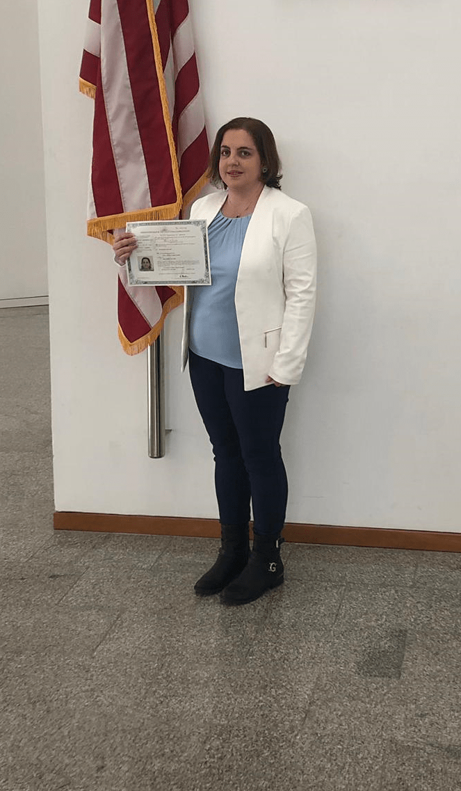 A woman is holding a citizenship certificate.
