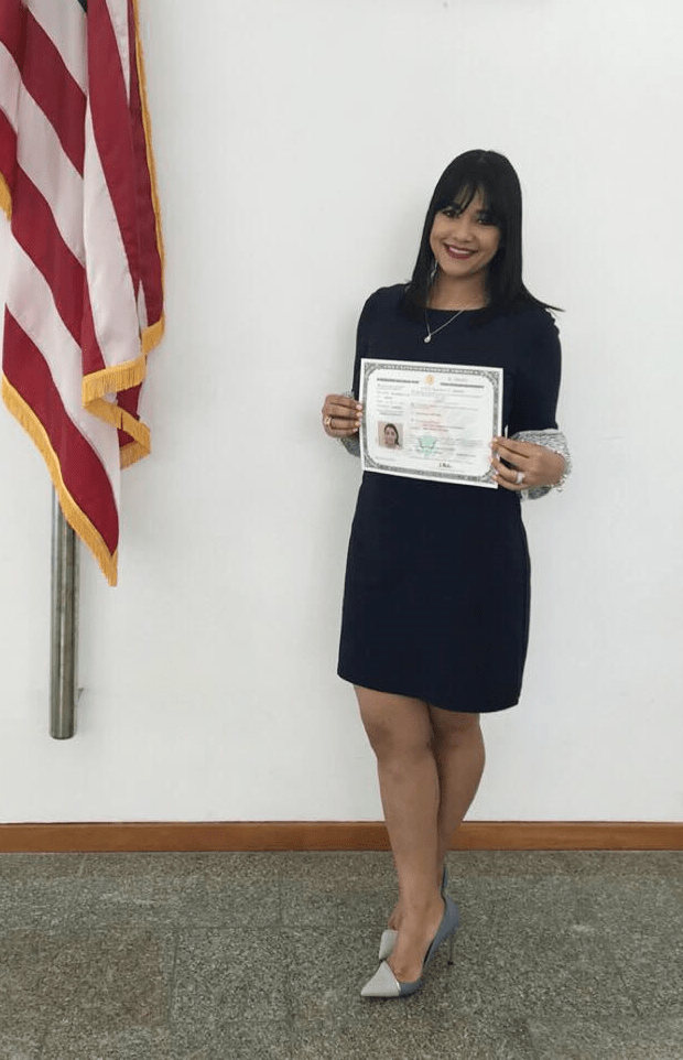 A woman is holding a citizenship certificate.