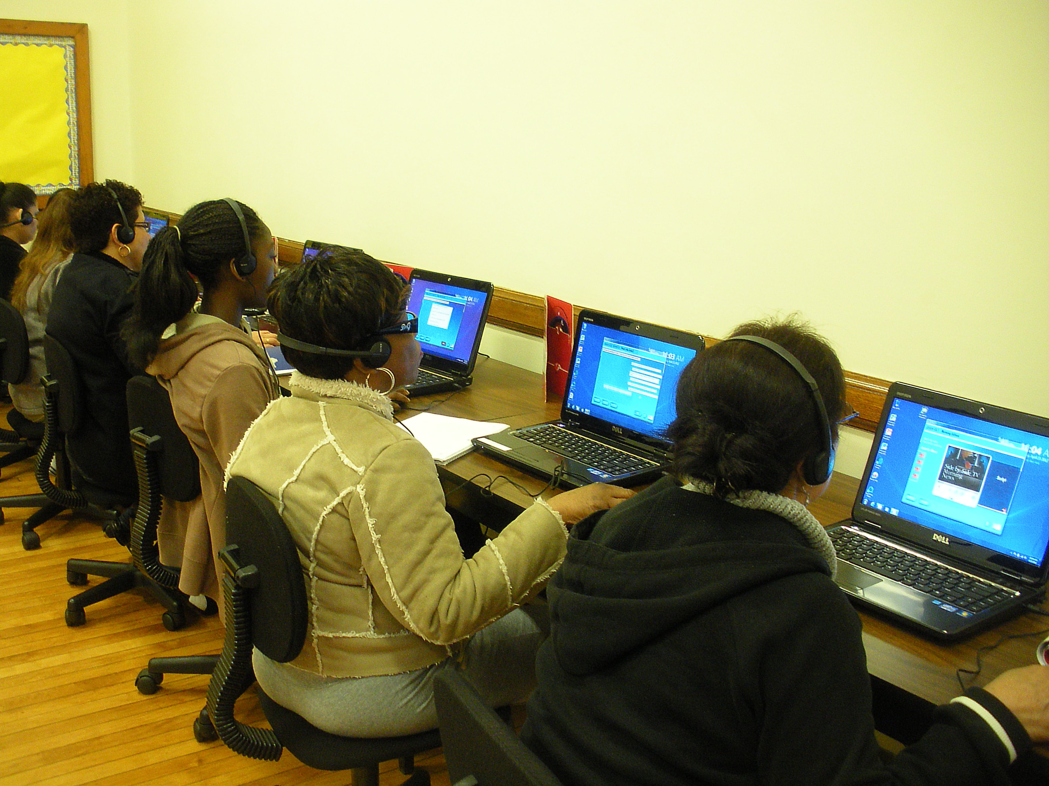 The computer lab: students sitting at desks, working on the computers. 