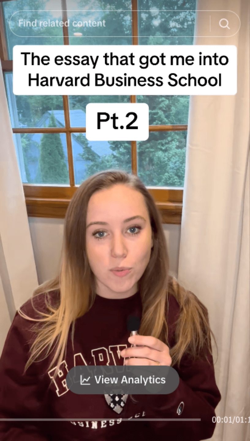 A woman wearing a maroon shirt and holding a microphone.