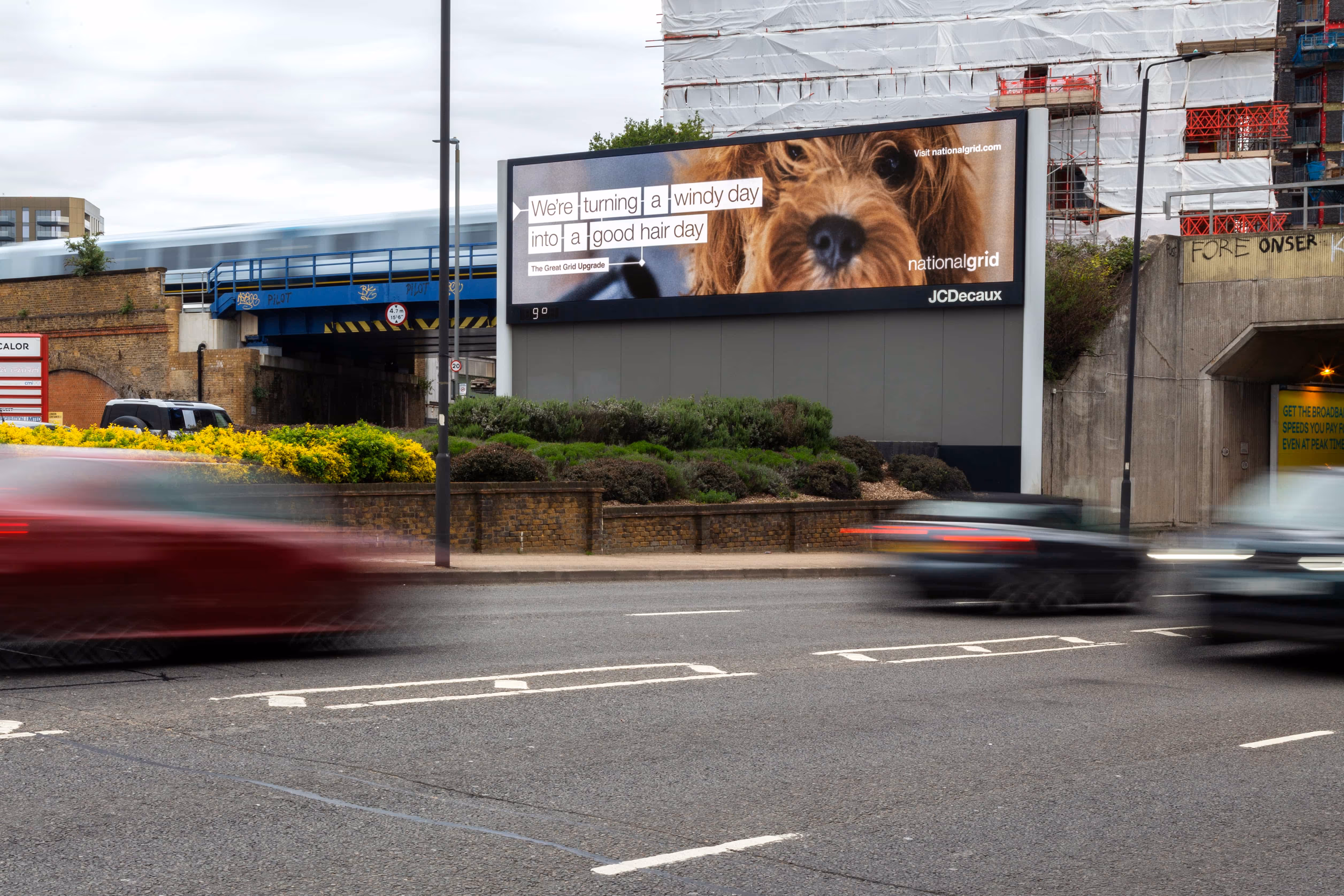 National Grid billboard with dog's hair blowing on windy street