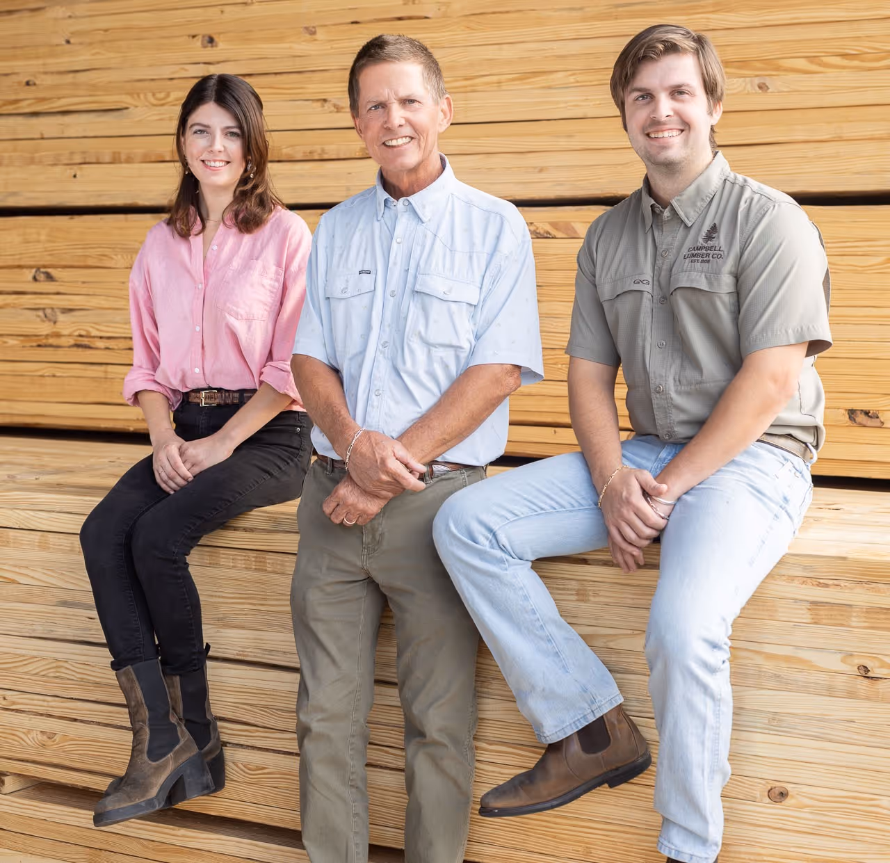 William Cyrus Campbell, Travis Clay Campbell, and Christian Marie Campbell sitting on a stack of lumber