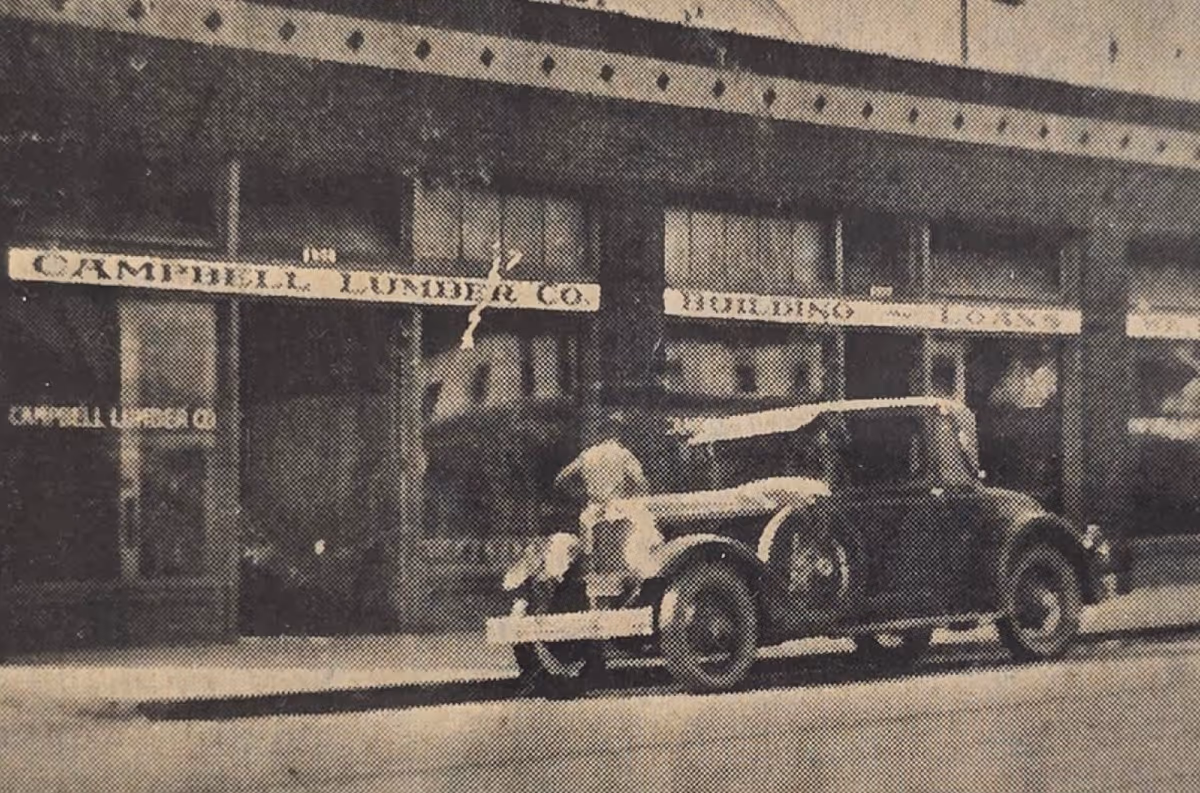 Vintage car parked in front of Campbell Lumber Co. storefront