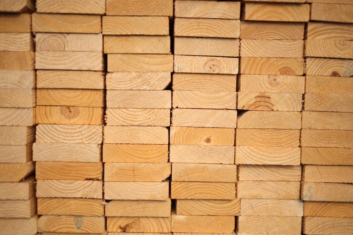 Stacked wooden planks with visible wood grain and growth rings