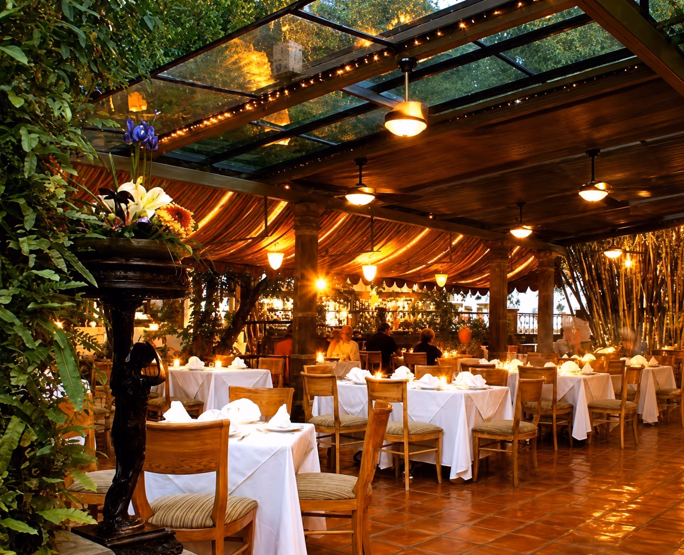El comedor en el jardín a la orilla del río de Le Bistro en la Isla del Cuale, Puerto Vallarta