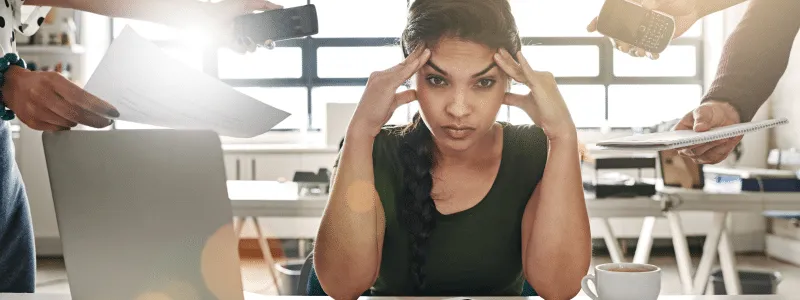 Young professional looking overwhelmed, illustrating how advocacy programs can help overcome internal change overload.