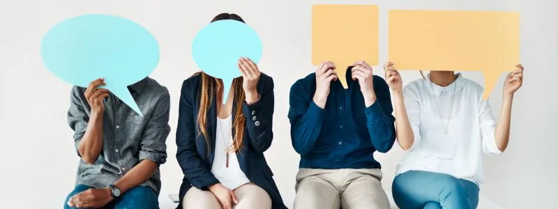 Four people sitting down with quote cutouts covering faces illustrating surverying customer marketing stakeholders.