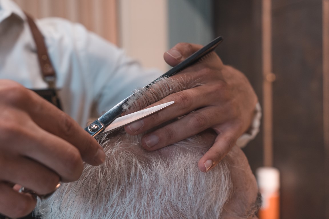 Salon stylist cutting a senior's hair at a senior living facility