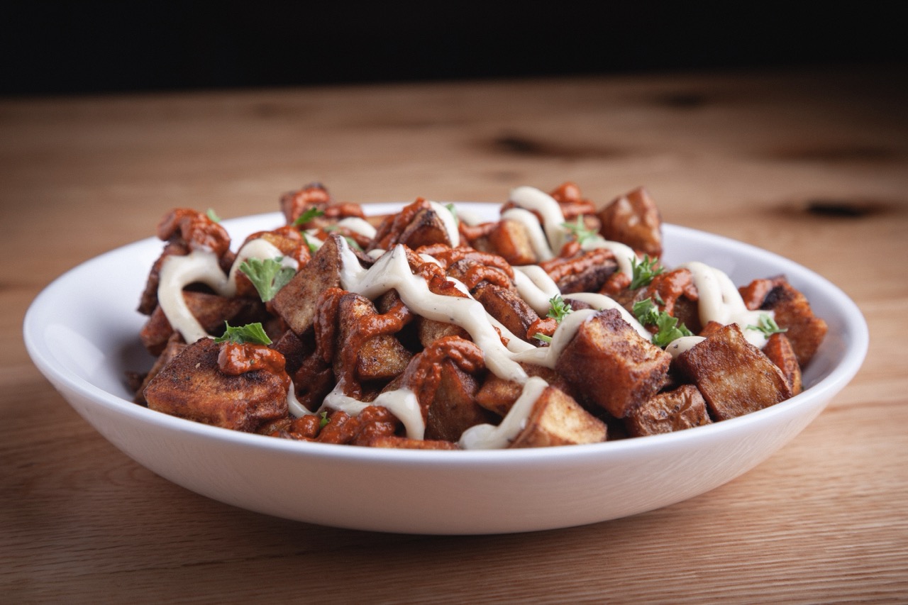 Crispy fried croquettes served on a white plate with roasted garlic aioli dipping sauce at DeWolf Brewing, Victor NY