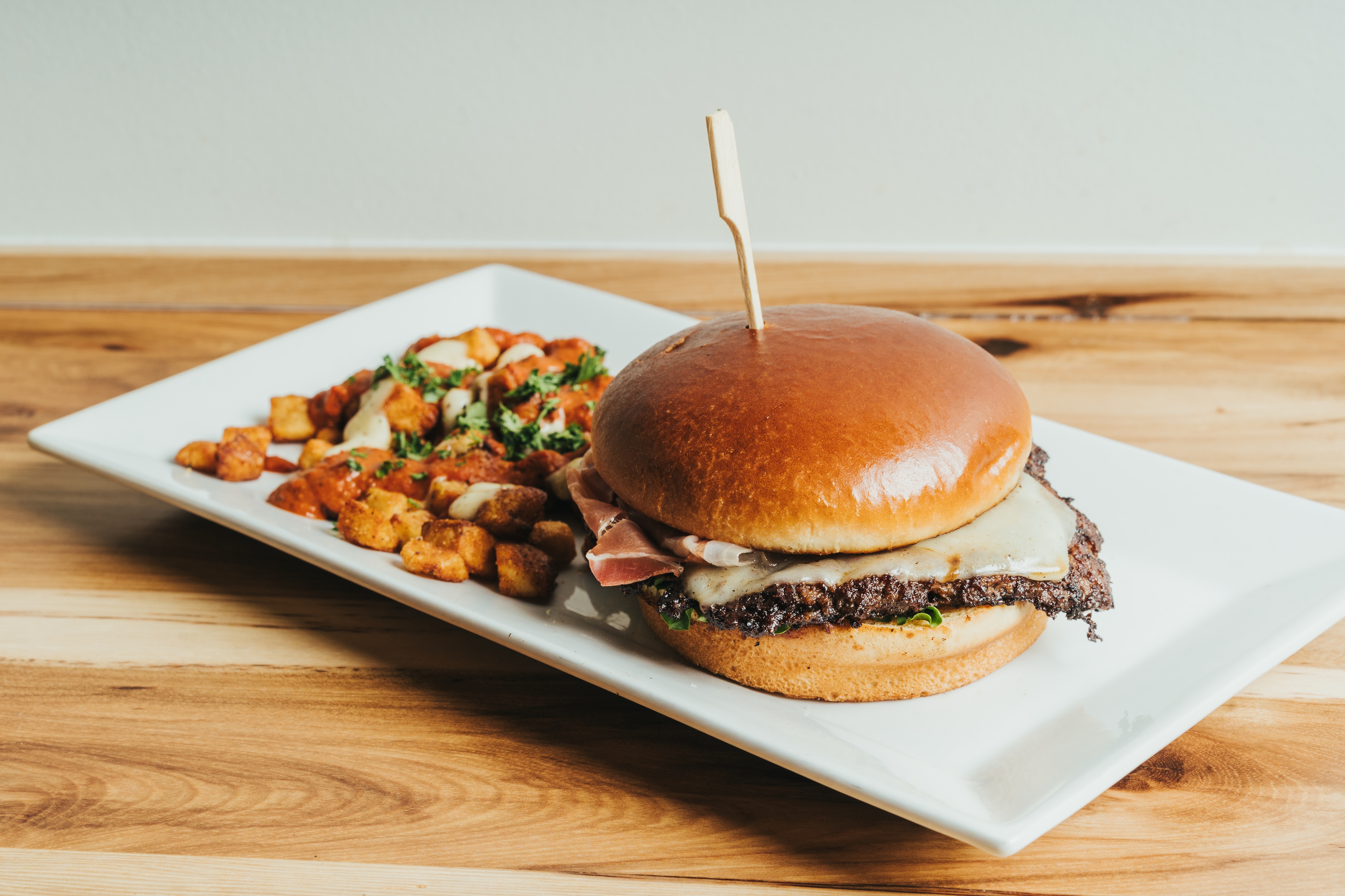 Crispy fried croquettes served on a white plate with roasted garlic aioli dipping sauce at DeWolf Brewing, Victor NY