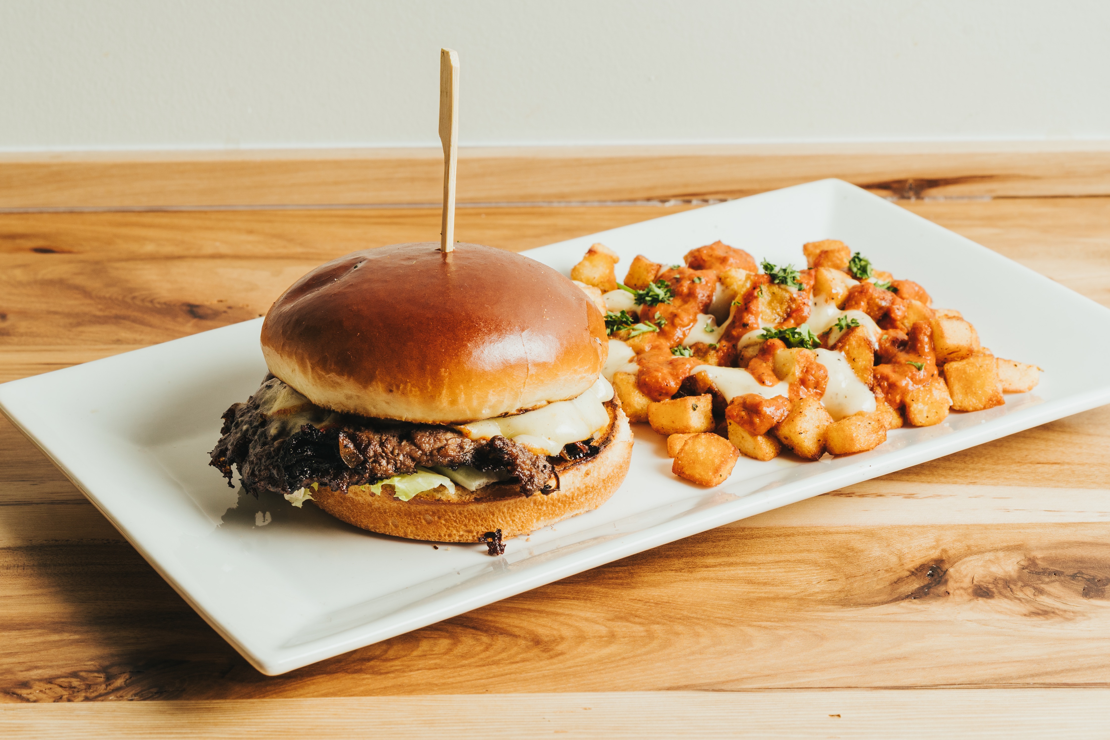 Crispy fried croquettes served on a white plate with roasted garlic aioli dipping sauce at DeWolf Brewing, Victor NY