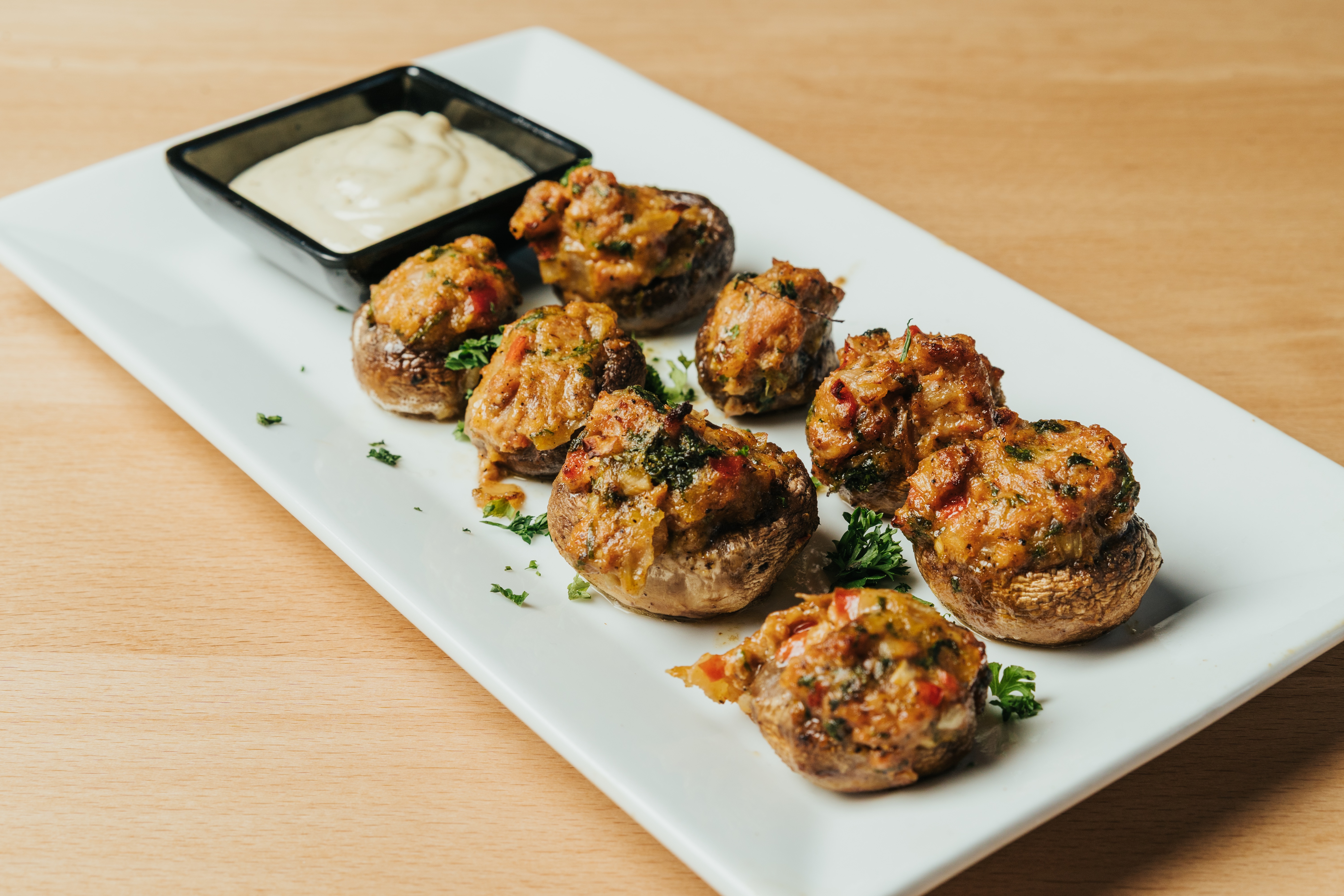 Crispy fried croquettes served on a white plate with roasted garlic aioli dipping sauce at DeWolf Brewing, Victor NY