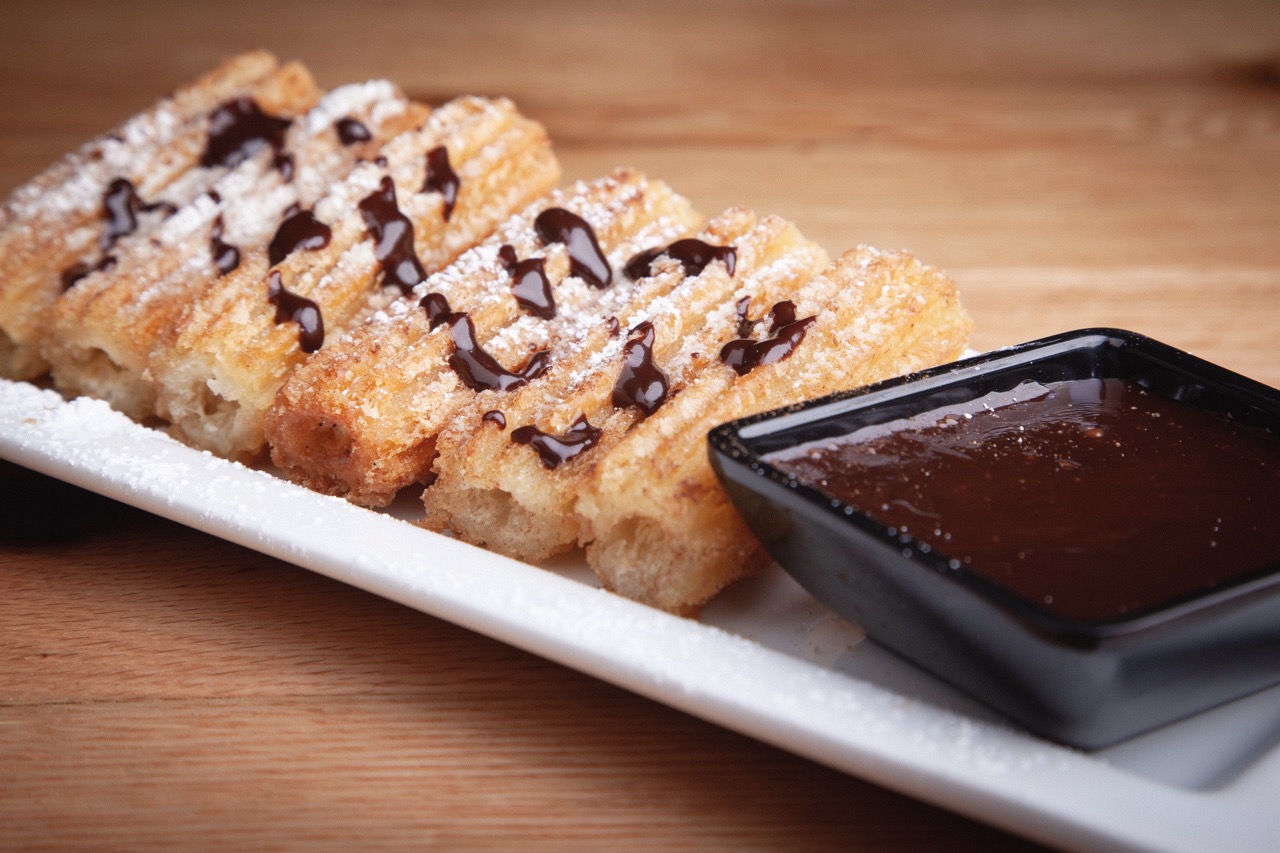 Crispy fried croquettes served on a white plate with roasted garlic aioli dipping sauce at DeWolf Brewing, Victor NY