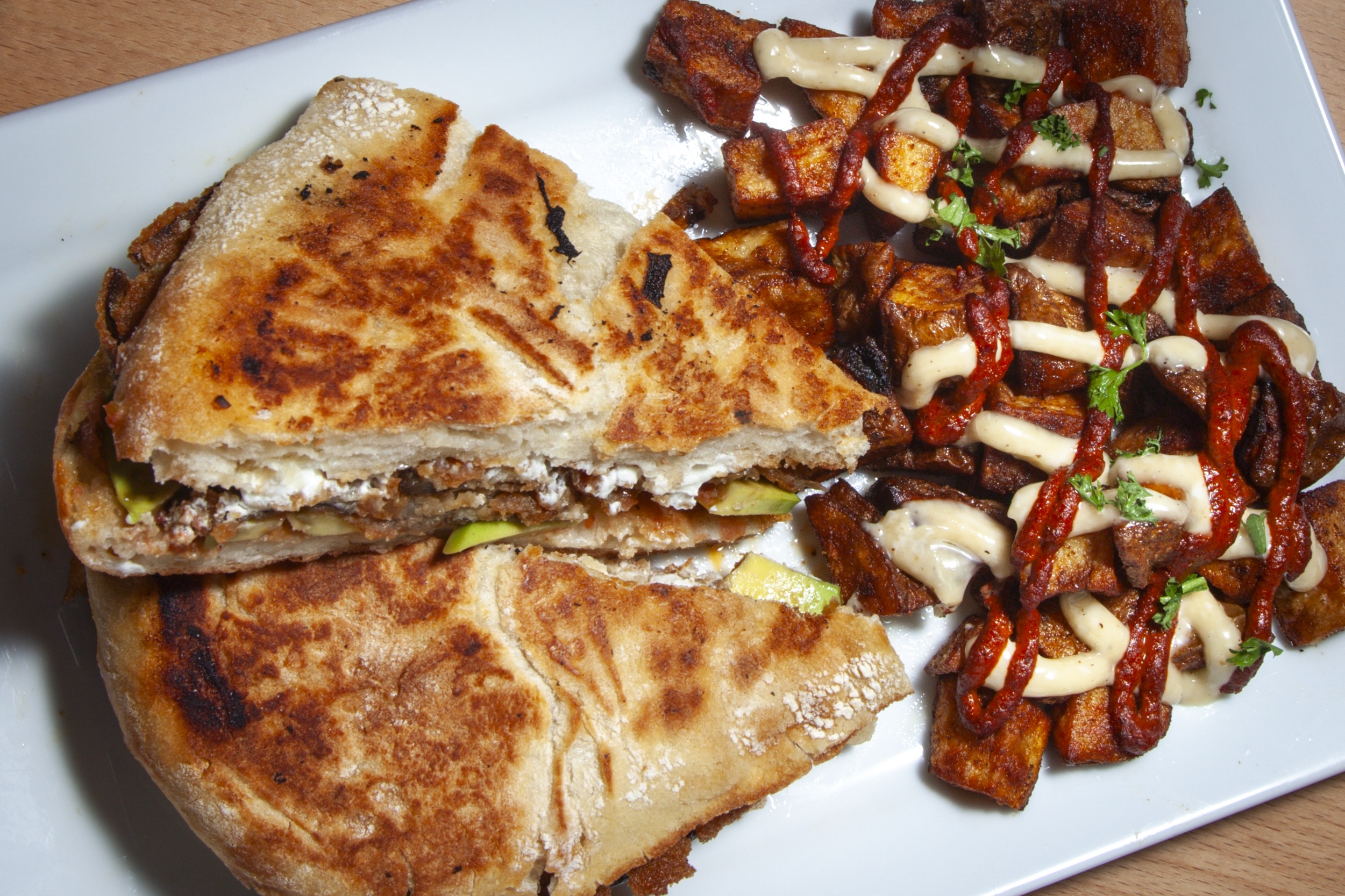 Crispy fried croquettes served on a white plate with roasted garlic aioli dipping sauce at DeWolf Brewing, Victor NY