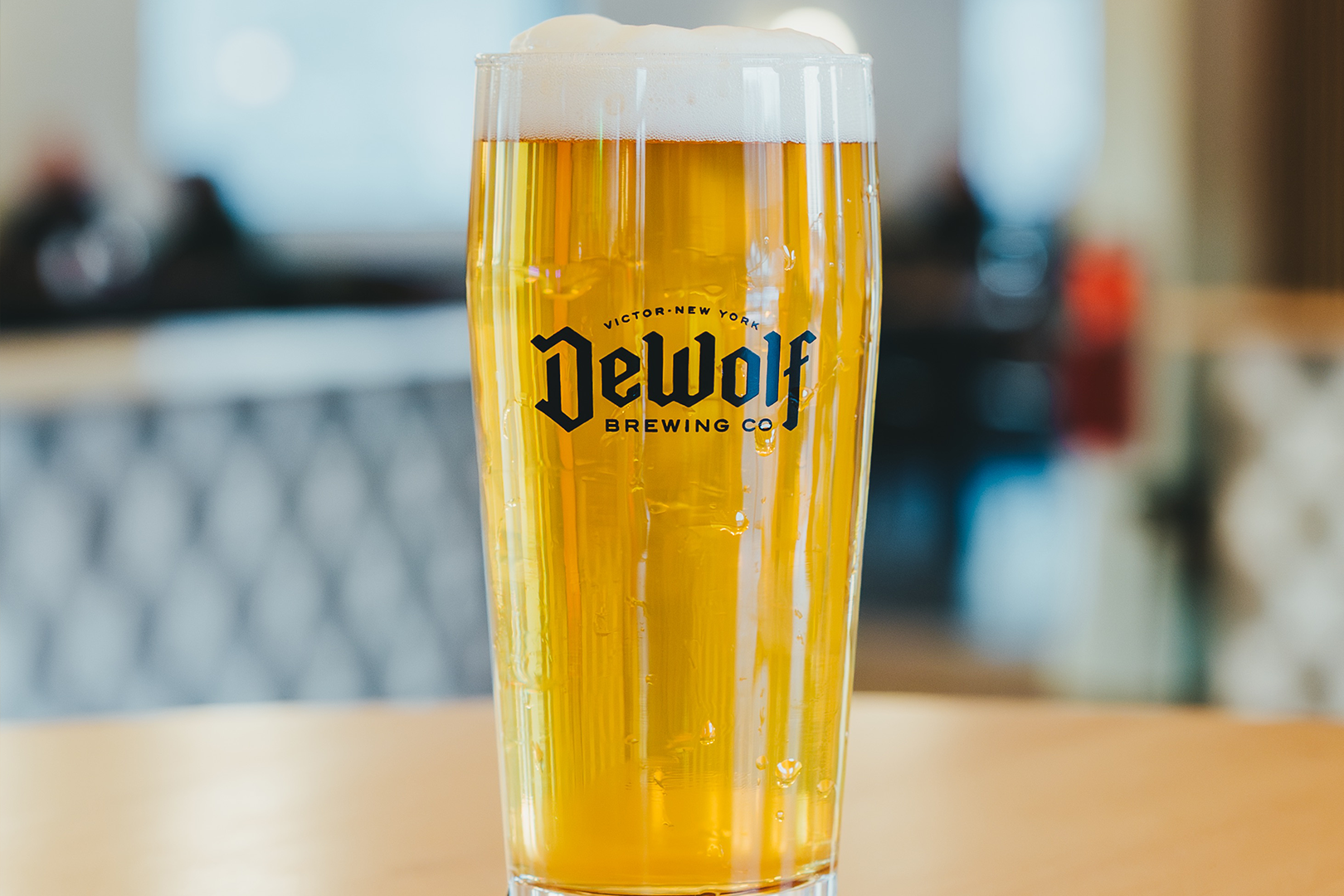 DeWolf Brewing Co. Kölsch style ale in a branded pint glass, brewed in Victor New York