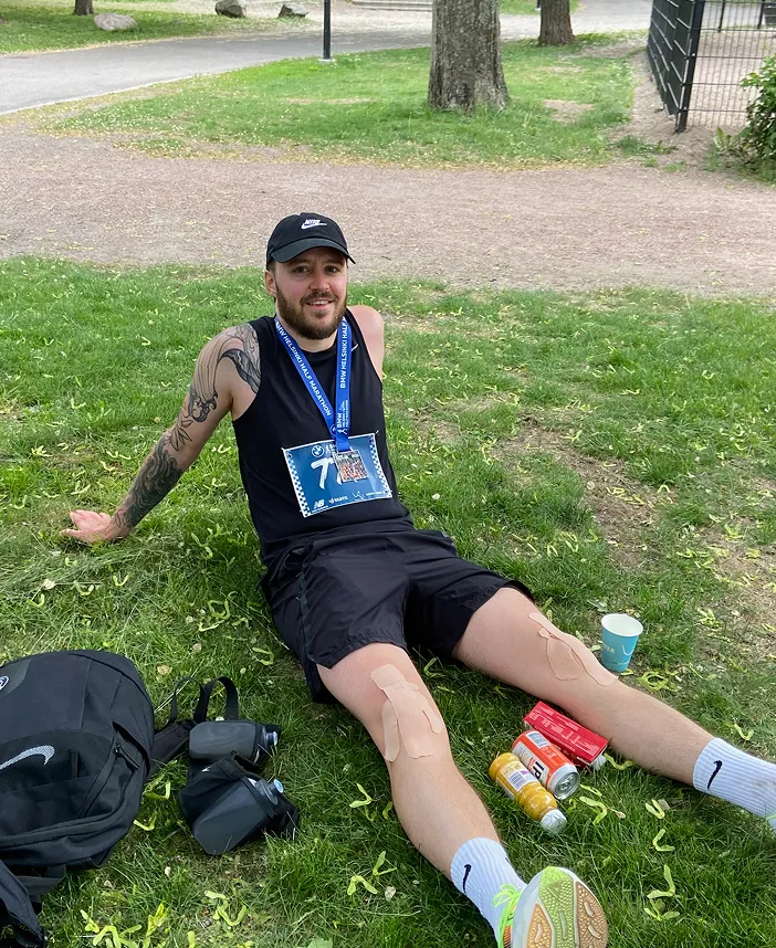 Félix Meens resting on the grass after finishing his half-marathon in 1h56