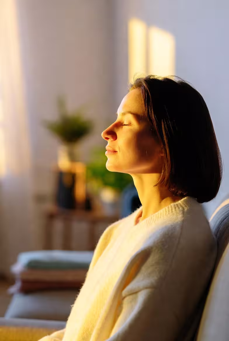 Caregiver standing in sunlight during a peaceful moment of reflection.