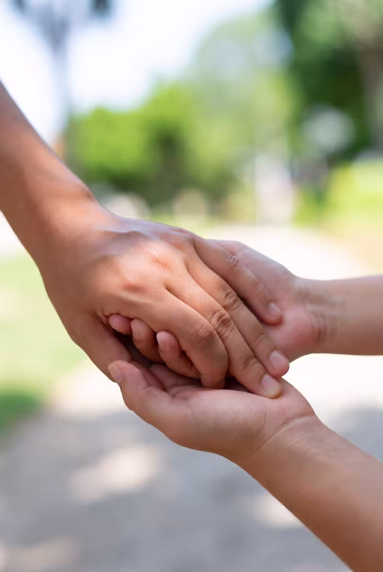 Close-up of hands showing caregiver support, reassurance, and connection.