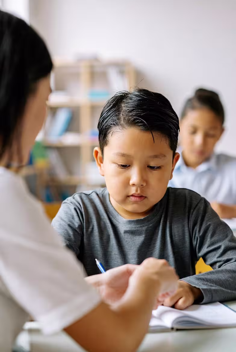Child participating in an IEP or school support meeting with adults nearby.