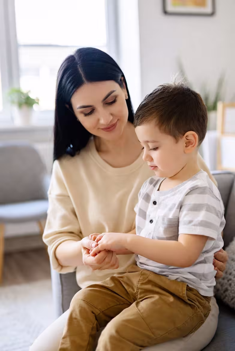 Mother helping a child with a daily learning or care activity.