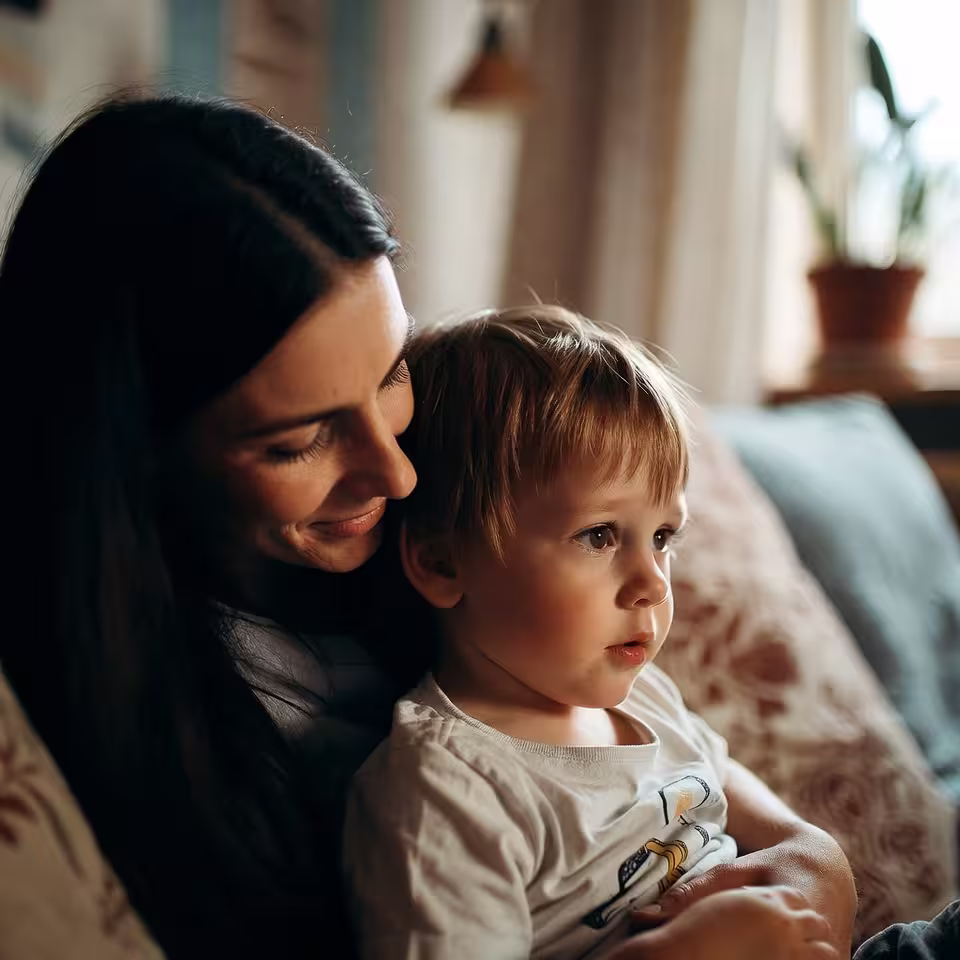 Mother holding a young child during a calm caregiving moment at home.