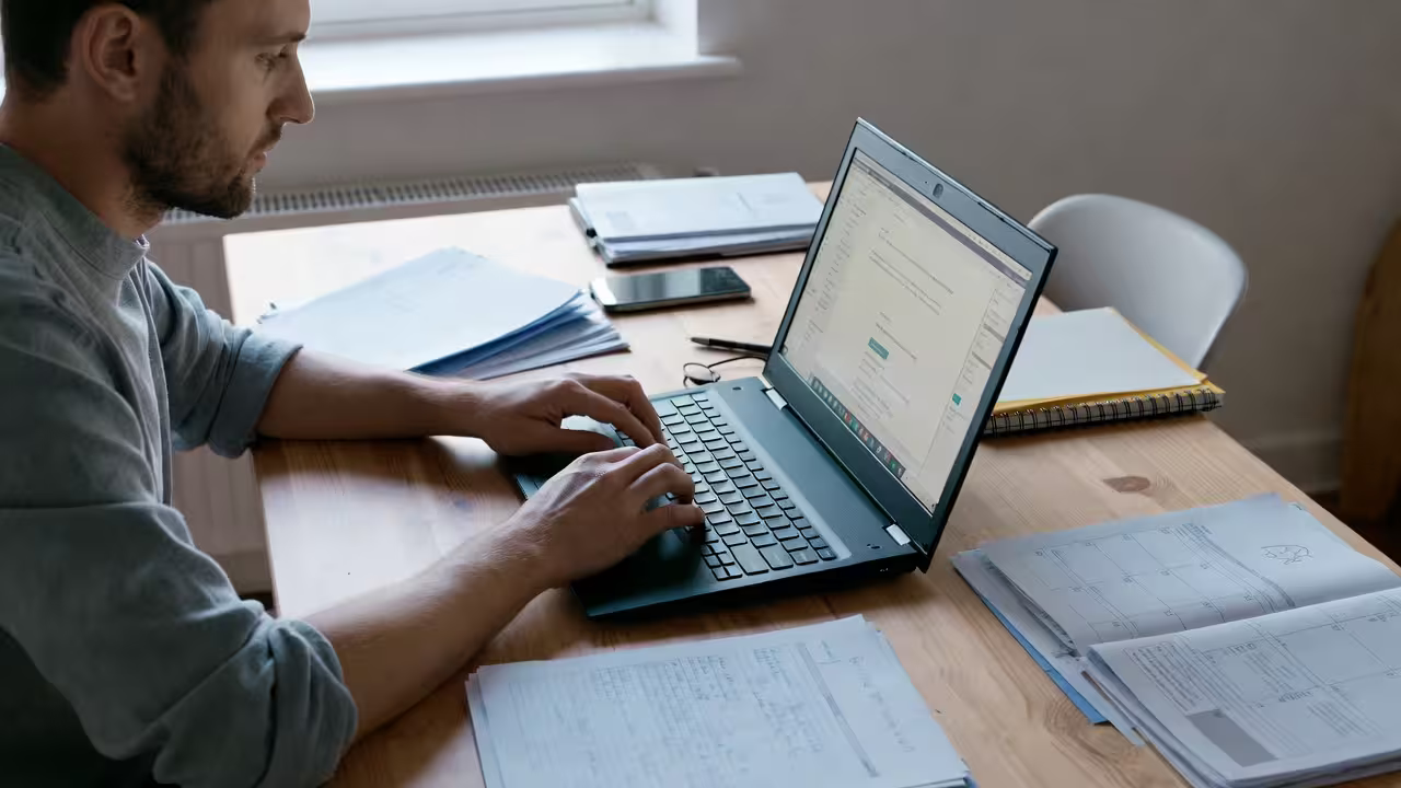 A father works with school documents at a desk — a typical situation for parents trying to understand their child's IEP or 504 plan