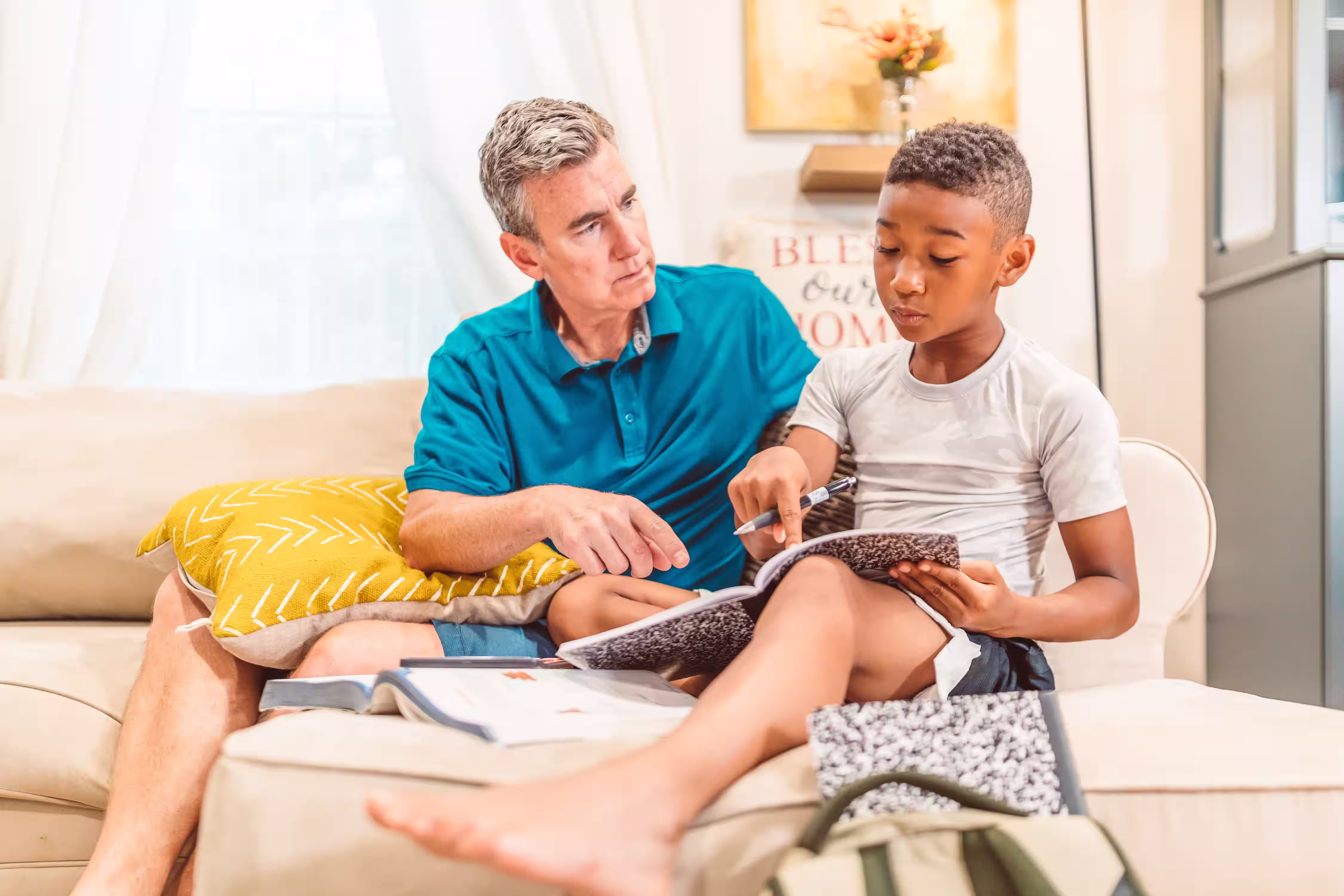 Adult and child using a notebook together for a school assignment.