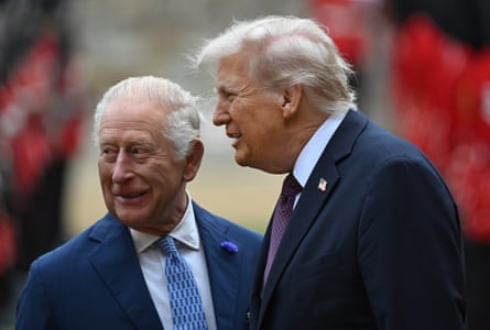 two men in suits smile as they speak with each other