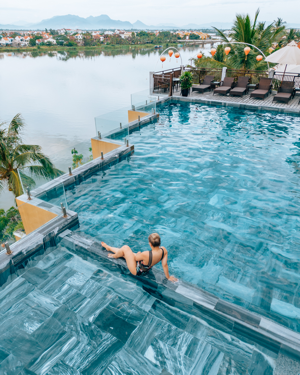 Photo of Cindy on the top of a pool in Hoi An, VIetnam overlooking a river
