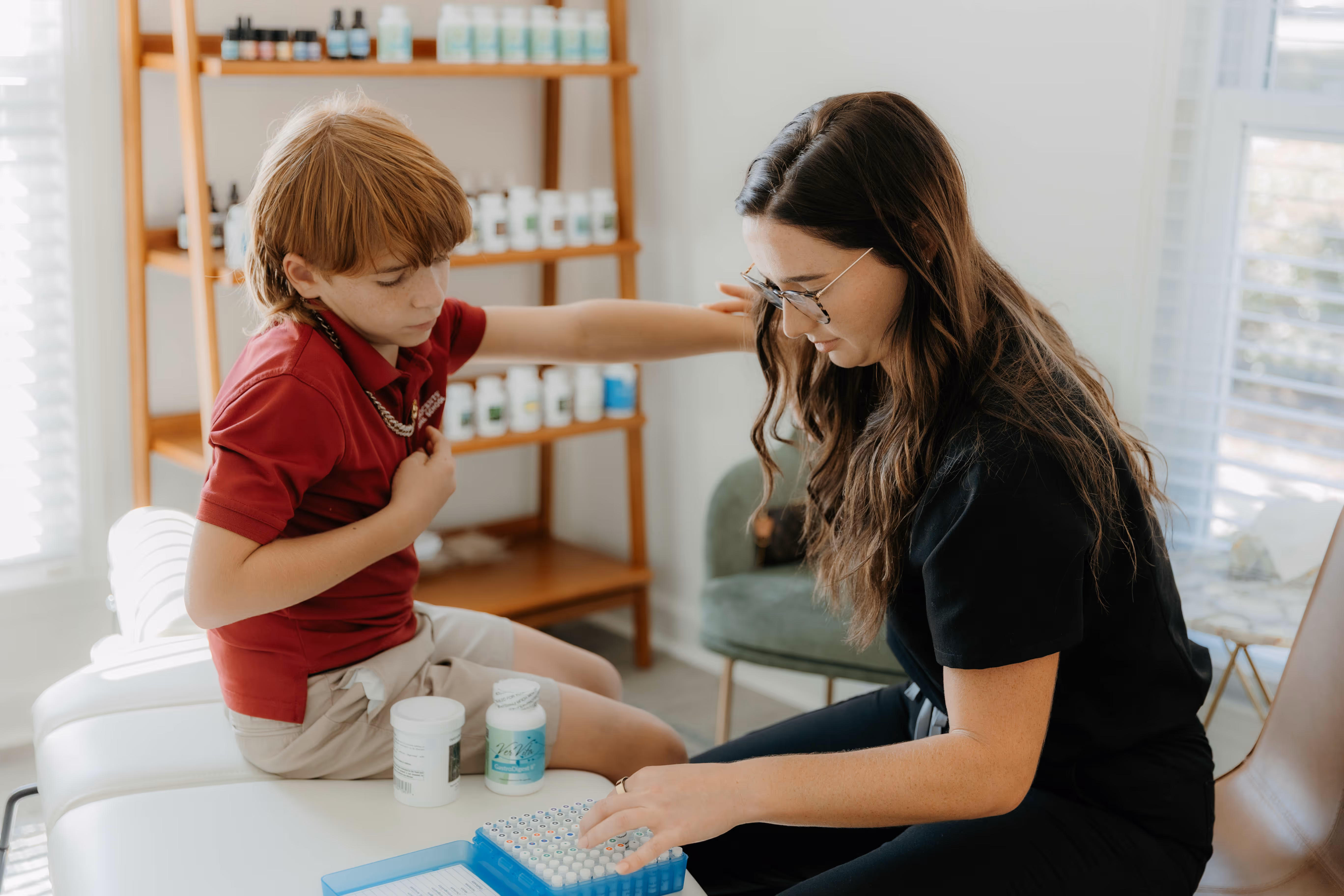 Dr. Bethany guiding young boy through functional QNRT and chiropractic-based wellness session.