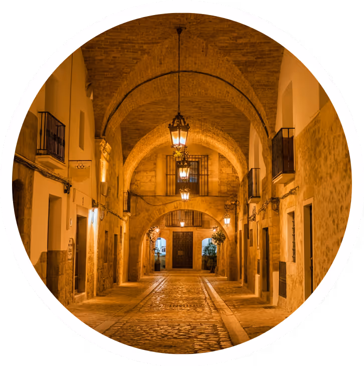 Arched stone alleyway in an old European town at night