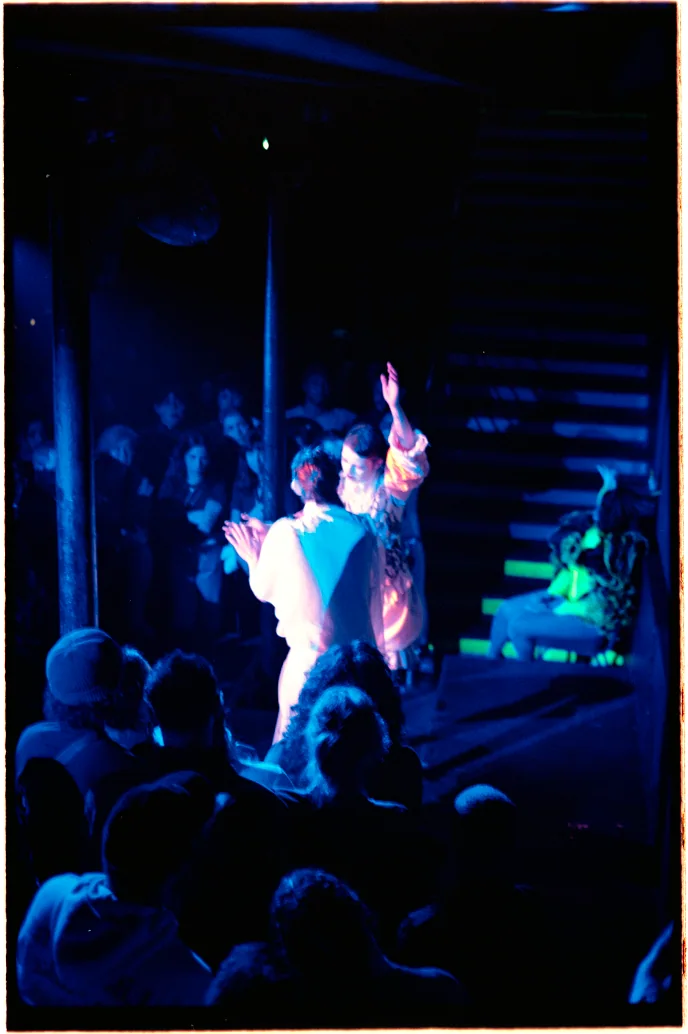 Performance de Foule à Lier, deux artistes sur scène face au public, lumière bleue