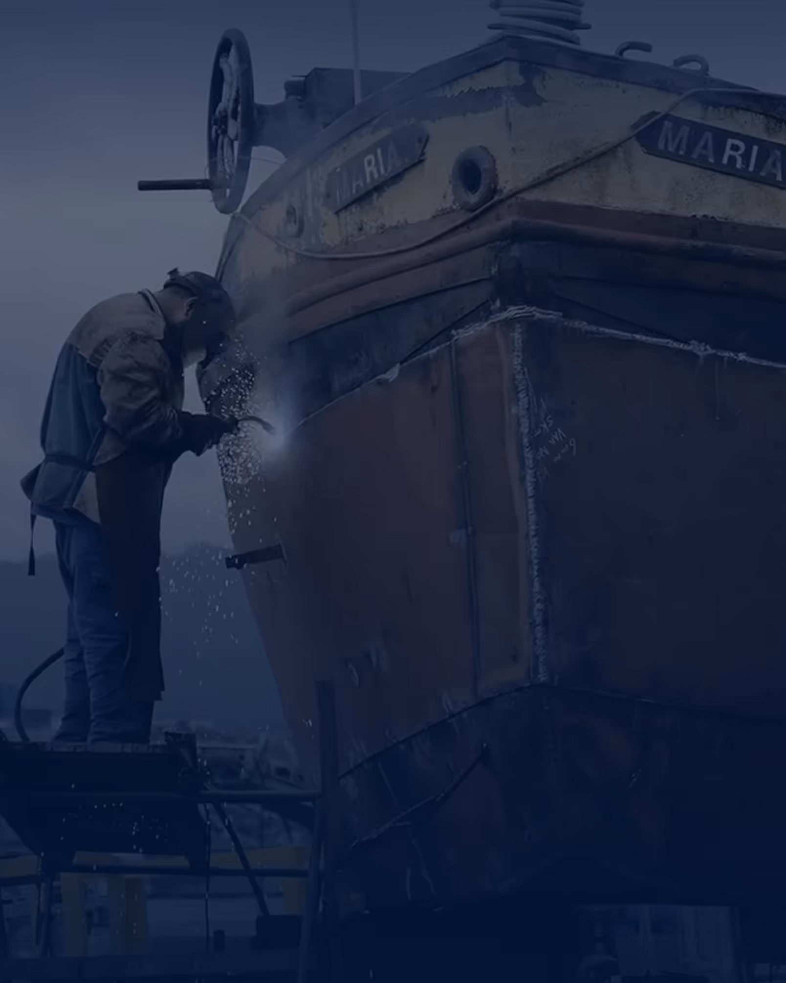 Werknemer last groot schip in werf.