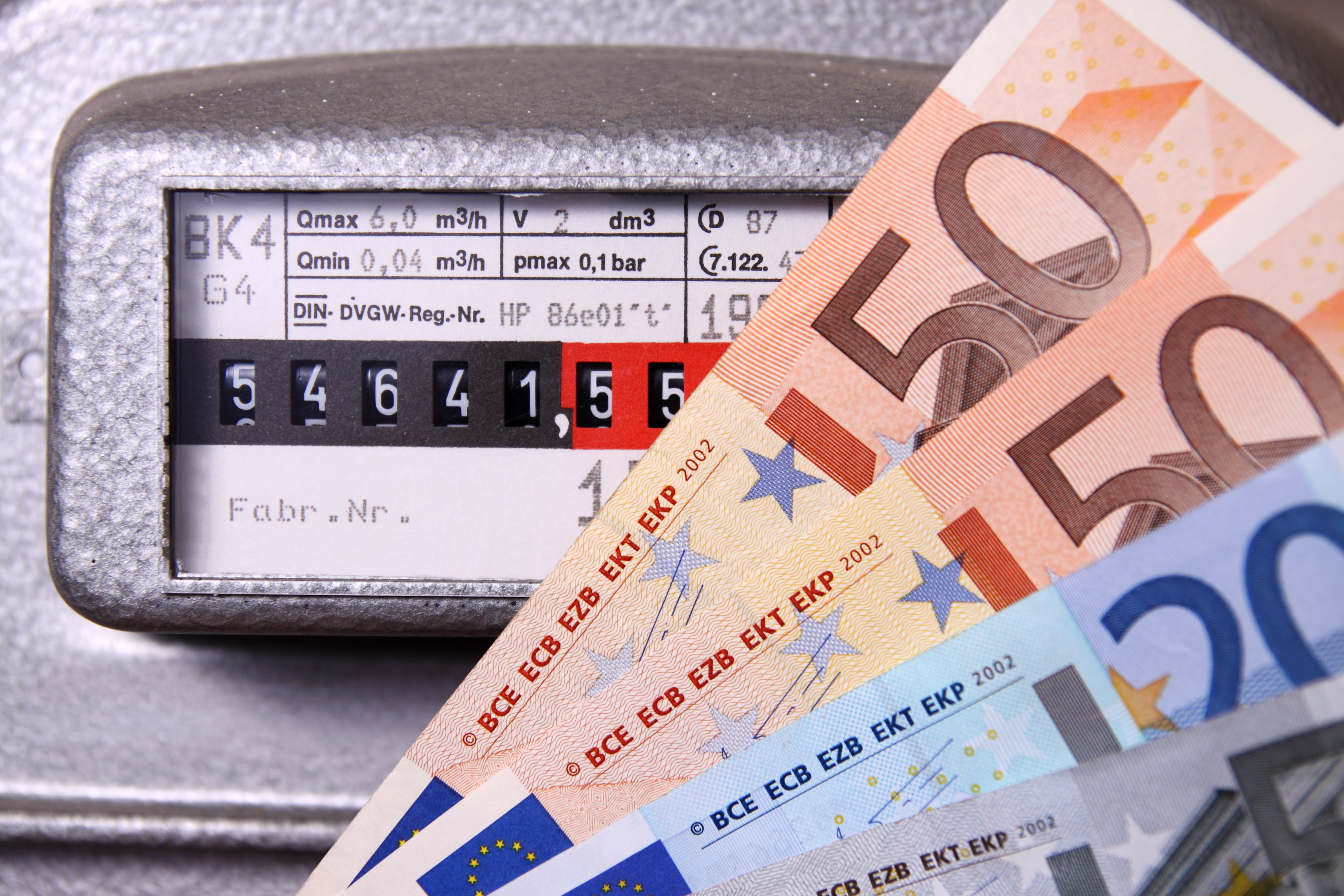 Gaszähler mit einem Zählerstand von 54641,55 und Euro-Banknoten in 50- und 20-Euro-Scheinen davor.