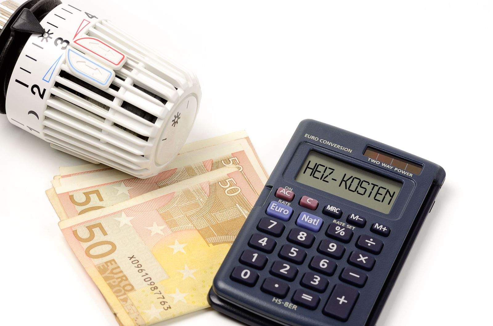 Taschenrechner mit "HEIZ-KOSTEN" auf dem Display + Thermostat und Geldscheine
