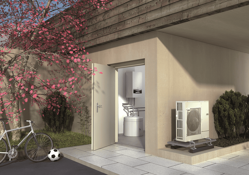 Wärmepumpe Kosten. Luftwärmepumpe von Buderus steht außen unter einem Carport an der Hauswand
