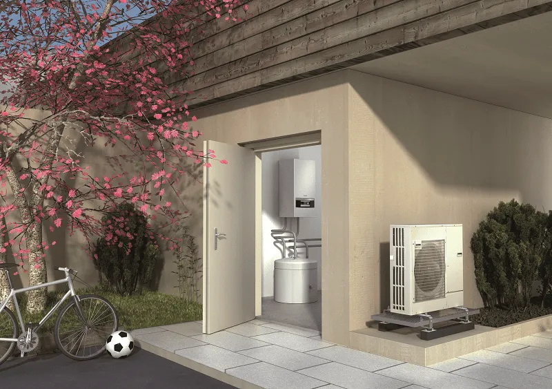 Wärmepumpe Kosten. Luftwärmepumpe von Buderus steht außen unter einem Carport an der Hauswand