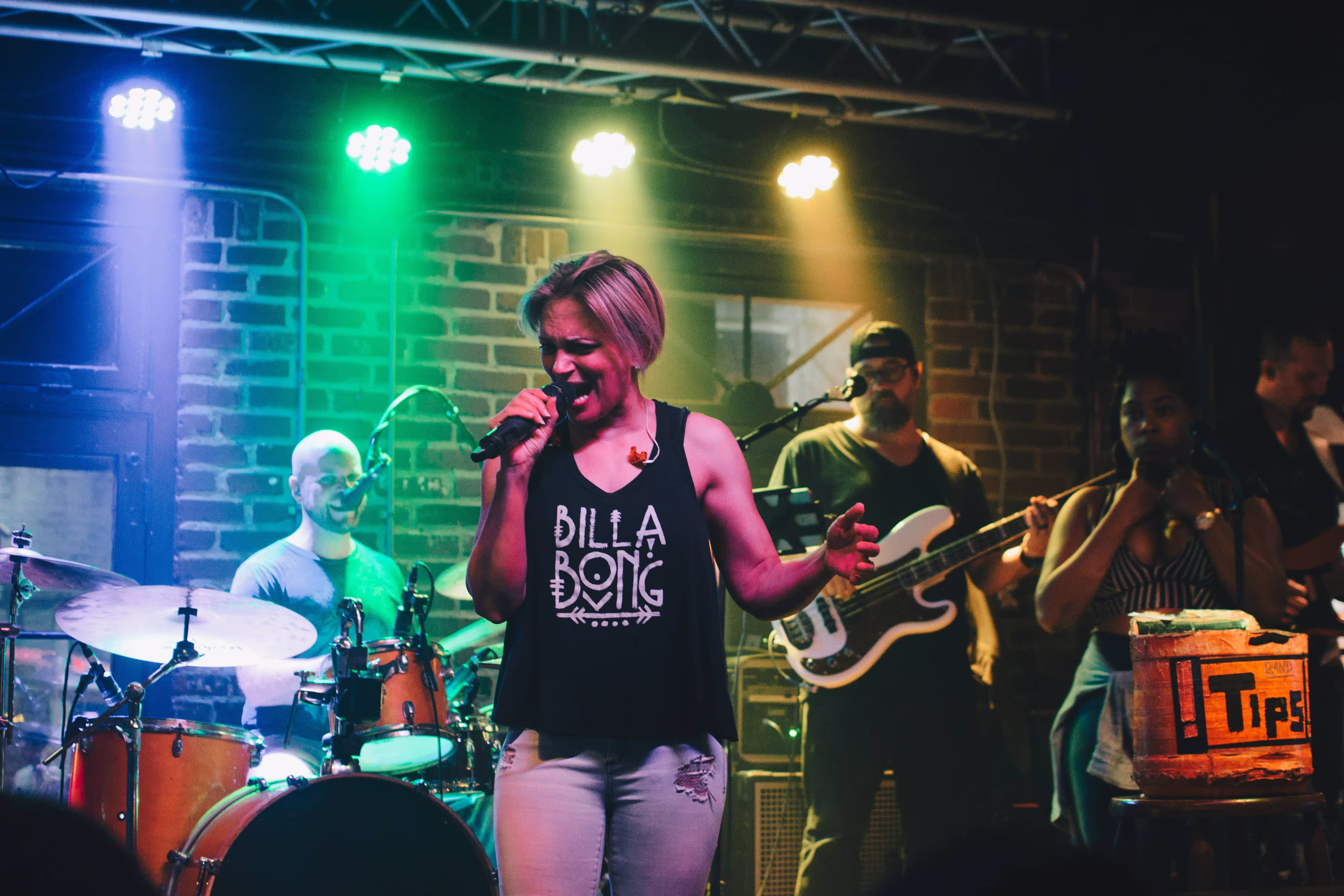 band performing live a a venue, woman singing with band playing behind her